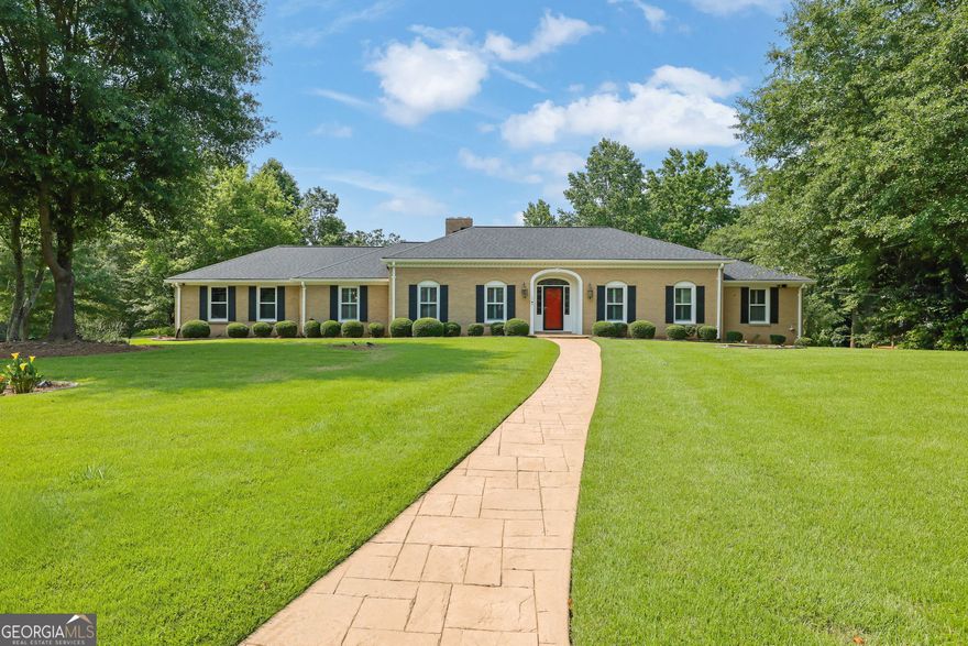 A premier offering in this 4-sided brick ranch nestled on a beautifully landscaped 1.3-acre corner lot in the heart of East Cobb. With over 5,300 square feet of refined living space, this residence exudes traditional elegance and modern comfort. From the moment you step into the gracious foyer, you'll notice the real hardwood floors, sophisticated living and dining rooms, plantation shutters, and a floorplan designed for everyday luxury and effortless entertaining. The chef's dream kitchen is a showstopper-featuring an expansive center island, granite countertops, stainless steel appliances, custom cabinetry, a Butler's pantry, built-in wine rack, and wine cooler. Just off the kitchen, a sun-drenched glass-enclosed sunroom provides the perfect destination for morning coffee or afternoon reading. The main-level primary suite is a serene retreat, offering dual closets and a spa-inspired en suite bath with a luxurious walk-in shower. The finished terrace level is a home unto itself-complete with a living room, full spirit bar, billiard room, game room, home office, a renovated full bathroom, private bedroom, dedicated spa room, and a fully equipped home theater with all AV equipment and seating included. Step outside to a backyard oasis. The expanded deck overlooks a lush, park-like setting featuring a sparkling gunite inground pool, a 15' x 12' greenhouse, matching shed, and a charming playset. Located in one of East Cobb's most sought-after school districts with convenient access to top-tier shopping, dining, and entertainment, this timeless estate offers the best of space, privacy, and sophistication.