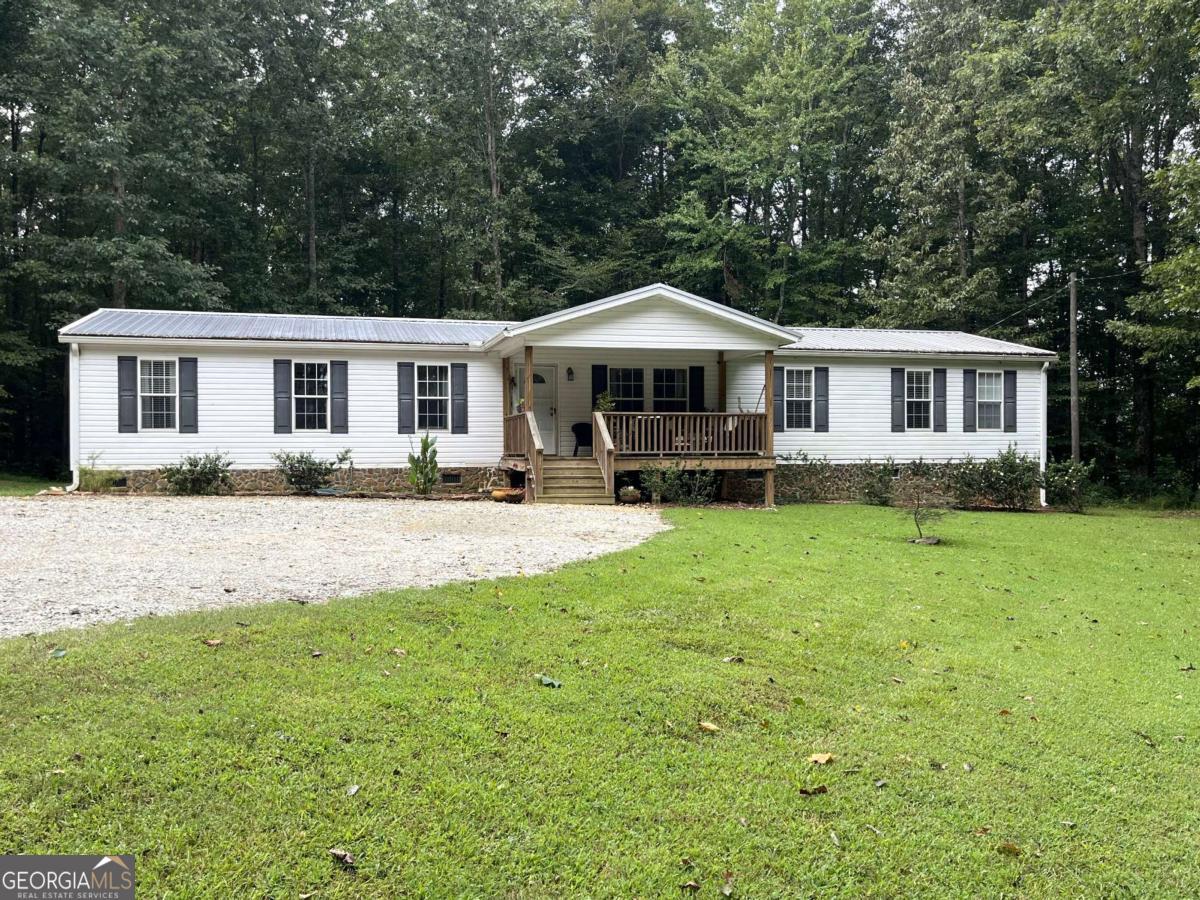 This attractive 4-bedroom mobile home sits on a sprawling 4.20-acre lot, offering privacy and room to breathe. Enjoy the tranquility of country living with the convenience of modern living. Recent upgrades include water heater, HVAC system, faucets, dryer and toilets ensuring peace of mind and energy efficiency. Step inside to the living room. The large kitchen, a central hub for family and friends, features ample counter space, storage and modern appliances perfect for entertaining or daily meal prep. A spacious island provides a convenient breakfast bar or additional prep space. The home offers plenty of flexible living space with both a dedicated living room and a den. The split bedroom plan provides privacy and comfort, ideal for families or those who enjoy hosting guests. The expansive 4-acre property is a wonderful opportunity to experience comfortable and private living. The outdoor building is unique and can be utilized in many different ways. Don't miss out on owning this one-of-a-kind property.