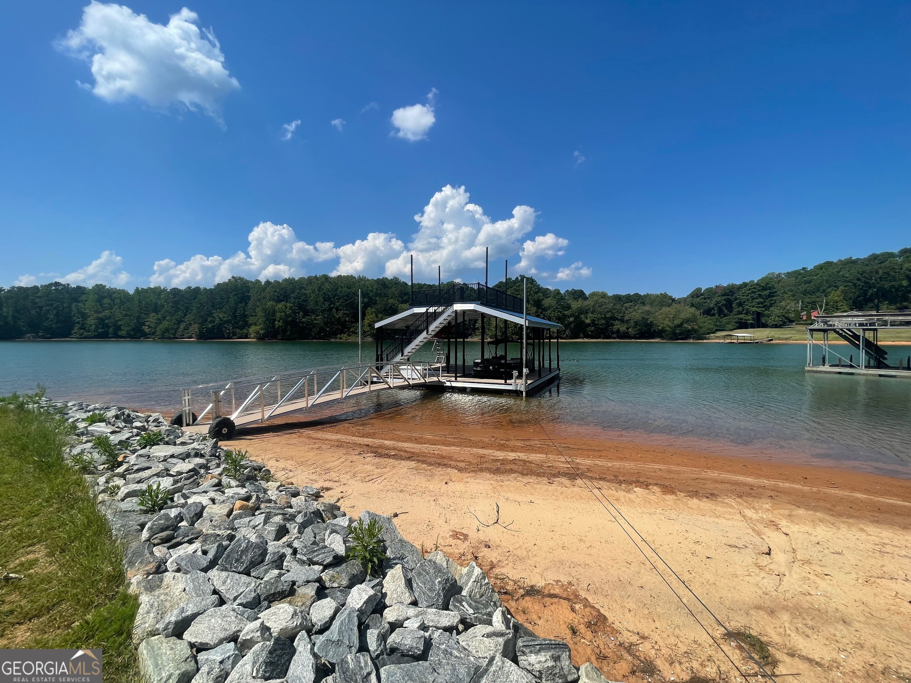 Incredible opportunity to build dream home on Lake Lanier. Only 2 lots remaining with grass to the water and mow permits, open view and rare gentle slope to the water. Located on a private road off Browns Bridge Rd. Just 3 miles from 400 in the coveted 6 mile cove. Very close to the new East Forsyth High School. This lot is permitted for a 32 by 32 Dock.
