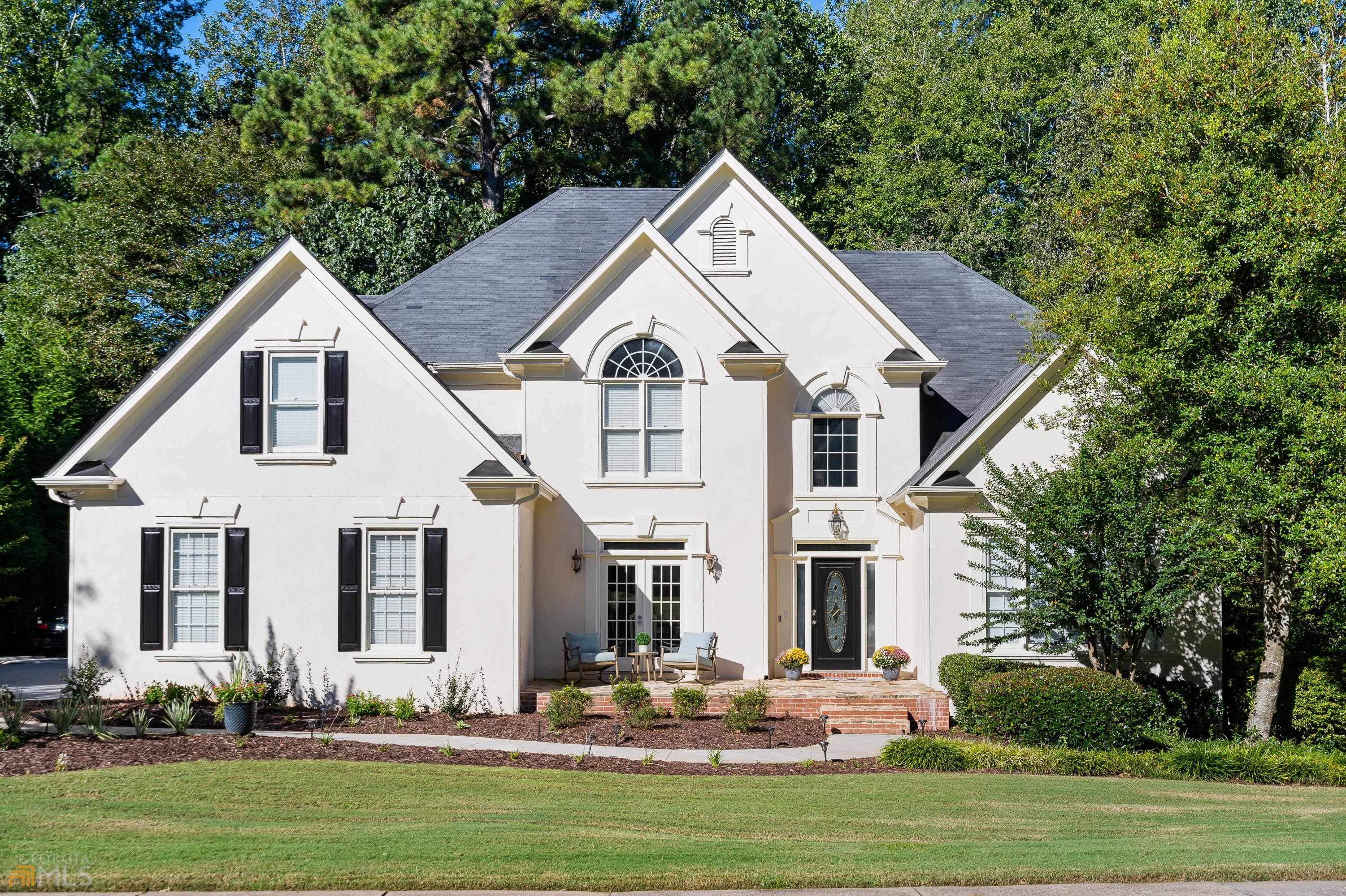 Beautiful newly updated home in Milton's highly sought gated/golf/swim/tennis community, Crooked Creek. This 4 bedroom 3.5 bathroom home has luxury finishes featuring modern, high-end details throughout. Key features include master on main, newly renovated kitchen and master bathroom, hardwoods throughout, unfinished basement and large private yard. As you step inside the two-story foyer, you're greeted with an abundance of natural light and an open floor plan. Your eyes will go straight to the sleek marble fireplace and modern staircase. The updated kitchen is a dream featuring quartz countertops, new cabinets, a double oven, and SS appliances. Cozy up in the sunroom off the kitchen, or relax on the back deck overlooking all the nature. End the day in the master suite and recently renovated master bath, marble throughout and amazing oversized closet! The upper level features 3 additional spacious bedrooms and 2 full baths. The unfinished basement offers endless possibilities. Zoned for Top rated schools, minutes from GA 400, and unbeatable neighborhood amenities - 11 tennis courts, waterpark pool, and social events for everyone.