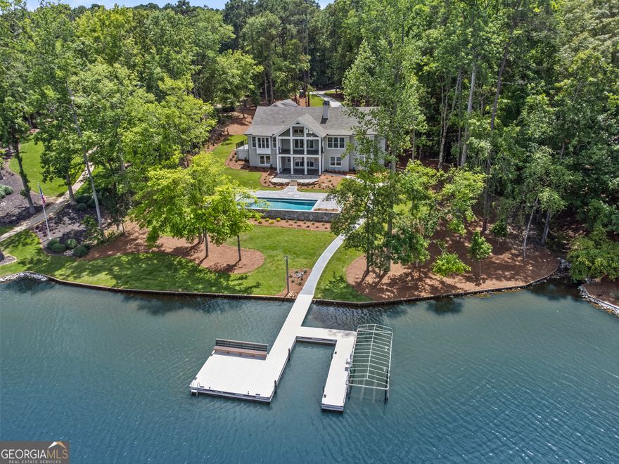 Welcome to your new dream lake home, completely remodeled and expanded, nestled in the prestigious Parrott's Cove section of Reynolds, near the Ritz and Richland Pointe by boat. This move-in ready, meticulously renovated, remodeled, gutted and extended lakefront home offers luxury living at its finest. It sits on over an acre of private land, with long meandering driveway and features a newly expanded 3-car garage.The private and sprawling backyard provide direct access to your spacious flat pool deck and boat dock. Property features over 5,400 square feet, 6 bedrooms, 5 bath and 2 half baths. It features a new roof, new tankless water heaters, new plumbing, new HVAC, new fixtures. The home was expanded to add new wing for bedrooms and living space on both the main and lower levels. Electrical and lighting were completely updated with modern systems. Whole house is pre-wired for whole house automation, ready for sound and smart home features.Luxury Gourmet Kitchen boasts Wolf 48" Dual Fuel Range, Sub-Zero Refrigerator, Cove dishwasher, Wolf microwave, new countertops and cabinets.Additional interior features include dining room with water views, new butlers pantry, new office, new lockers. Great room boasts vaulted ceiling and fireplace complemented by a spacious porch overlooking lake. Primary suite with luxury bath located on the main level. A second suite with bath also on the main level for added convenience. Descend to the terrace level that features a new big family and game room, new bar, new wine cellar and three additional en suites, perfect for family and guests. Bonus room is perfect for a future bunk or craft room. Step out to your huge pool patio with new 18x38 pool, equipped with automated controls, LED lighting, and premium Jandy equipment for effortless enjoyment and maintenance. This stunning property offers a perfect blend of modern luxury and timeless elegance, set in a serene lakefront location. Don't miss this rare opportunity to own a new fully remodeled and expanded home in one of the most sought-after neighborhoods in Reynolds Lake Oconee. Membership available.