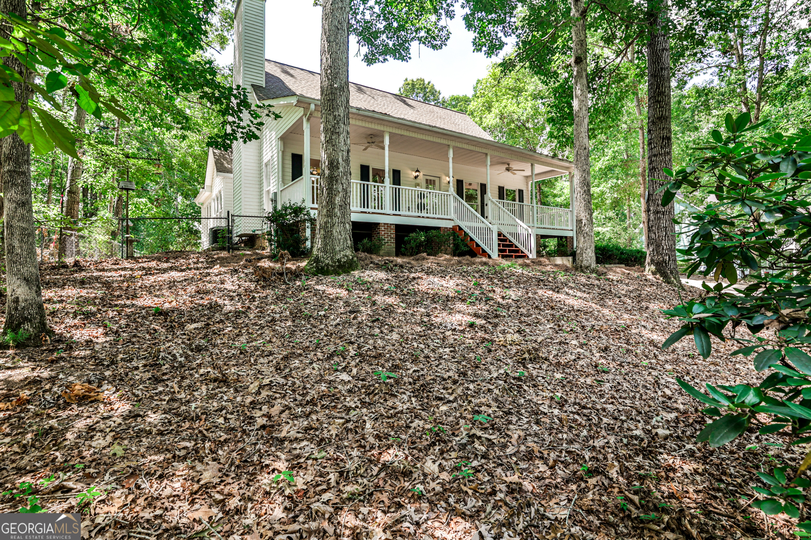 Your Private Hilltop Paradise Awaits! Escape subdivision living to this serene, private, and well-maintained home north of metro Atlanta, offering ultimate freedom and space. Step onto the huge, welcoming front porch. Inside, find warm hardwood floors on the main, including an oversized master suite with a large double-vanity bath. The beautiful sunroom is open to the kitchen and family room. Upstairs features two spacious bedrooms and a full bath. The basement apartment offers an exceptional opportunity for extended family or potential income, complete with a private entry, dedicated parking space, full kitchen, bath, bedroom, living space, storage, and luxury vinyl plank flooring. Situated on an almost-acre level lot at the end of a long, gentle driveway, this oasis boasts plenty of parking for your boat, camper, ATVs, and vehicles. A detached two-car garage is ideal for your cars or as a workshop. Enjoy more privacy than a subdivision, and with no HOA, you have unmatched freedom. Located less than 10 minutes to GA-400, prime shopping, and restaurants, you're also very close to Lake Lanier, with easy access via Thompson Creek Park less than a 5-minute drive away. Have peace of mind knowing that it includes a 1.5-year-old water heater, a 5-year-old roof, and newer HVAC equipment. Whether you seek a private sanctuary, a versatile family estate, or a home with income potential, this extraordinary piece of paradise awaits!
