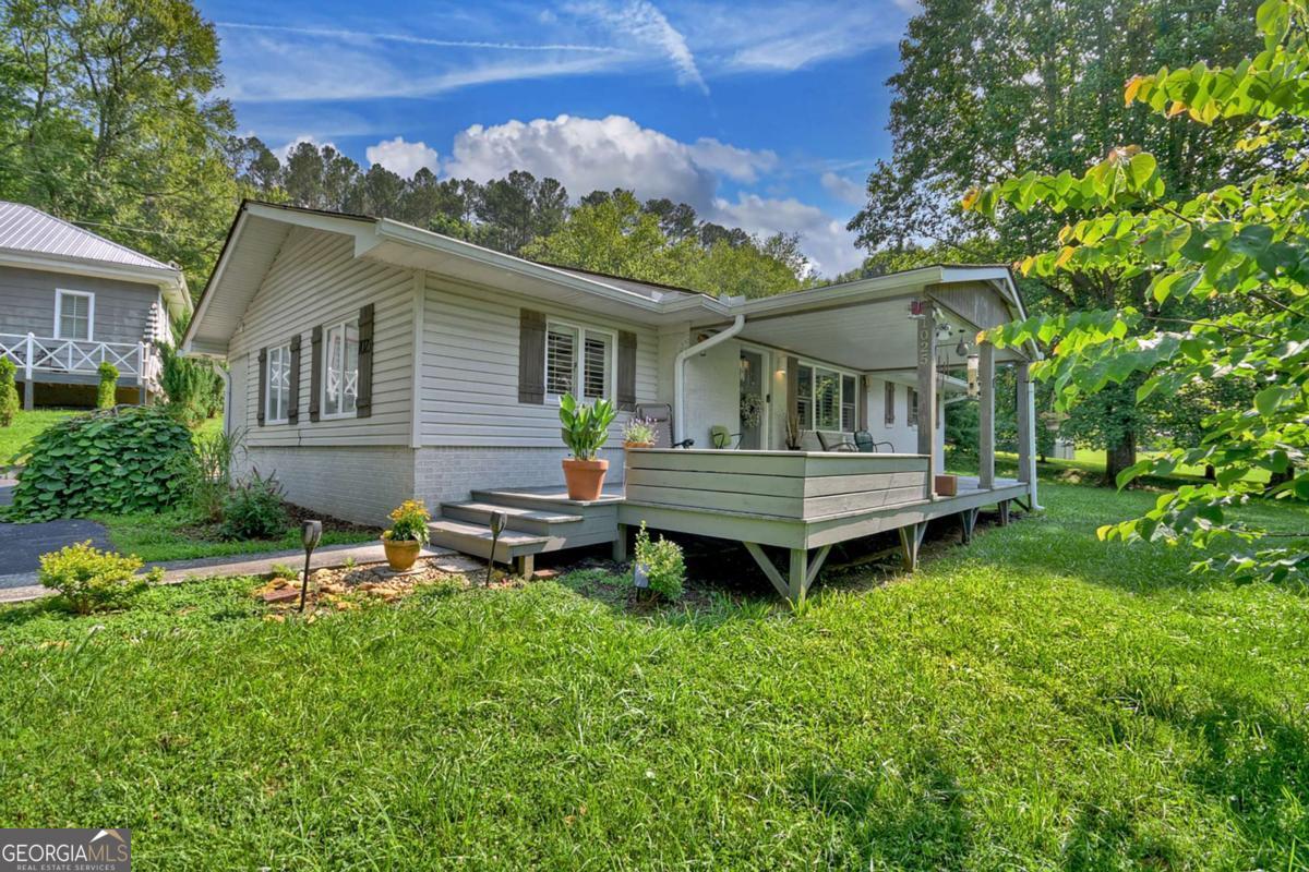 Welcome to this cozy 3-bedroom, 1.5-bath cottage bursting with personality and character, nestled just minutes from downtown McCaysville and the Toccoa River. Whether you're seeking a full-time residence, short-term rental, or long-term investment, this home offers comfort, charm, and flexibility in one package. Inside, you'll find original hardwood floors, a beautifully updated kitchen with open shelving, stainless steel appliances, and vintage touches throughout. The warm and inviting living spaces blend modern comfort with nostalgic cottage style. A bonus flex room-perfect for a bunk room, playroom, or extra lounge-makes hosting friends and family a breeze. The full bath features a stylish black-and-white tiled floor and a sleek tiled shower with grid-glass doors. Outside, the yard is just as charming, with mature landscaping, old-growth trees, and plenty of room for outdoor living or future garden plans. There's ample parking space to accommodate guests or multiple vehicles. Just a mile from Horseshoe Bend Park and mere minutes to restaurants, shops, and riverside adventures, this property is perfectly placed for relaxation and convenience.