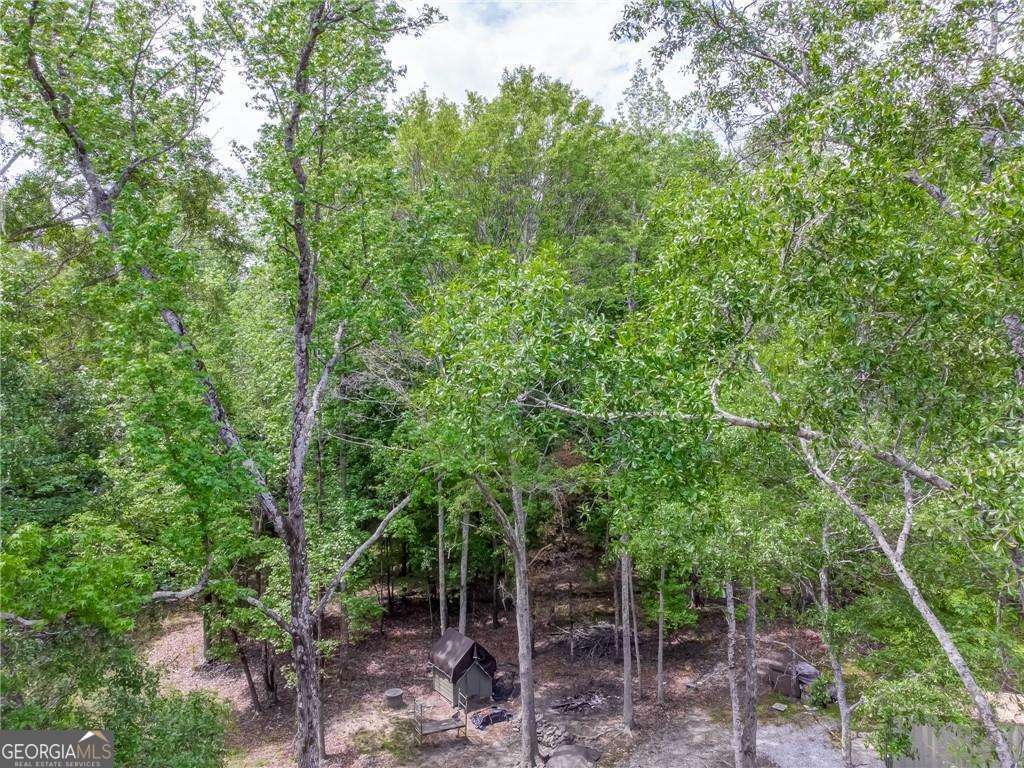 Discover this charming single-family home, built in 2017, where modern comfort meets rustic charm. Nestled on a sprawling 18.84-acre estate, the property offers a rare blend of lush wooded surroundings, open land, and the soothing presence of the North Oconee River. Inside, the thoughtfully designed floor plan features 2 bedrooms and 2 full bathrooms, with the master suite conveniently located on the main level. The cozy family room, complete with a gas-log fireplace, creates a warm gathering space, while the kitchen comes fully equipped with a dishwasher, electric range, microwave, garbage disposal, and solar hot water system. Additional comforts include central heating and air, ceiling fans, hardwood, carpet, and ceramic tile flooring, plus extras like a double vanity, walk-in closet, foyer entry, and attic stairs. The main-level laundry room adds everyday convenience. Step outside to your private deck or porch, the perfect spot to relax, entertain, or simply enjoy peaceful river views and quiet moments surrounded by nature. Ideally located, the home is just 1 hour north of Atlanta, 20 minutes from Athens, 19 minutes from the University of Georgia, and only 9 minutes from Jefferson town square with quick access to I-85. Families will appreciate the highly regarded Jefferson City School System, ranked among the best year after year. Whether you're a nature lover craving privacy, a professional commuting to Athens, or seeking a serene retreat-style residence, this home offers the best of both worlds-secluded living with convenient access to modern amenities and regional hubs.