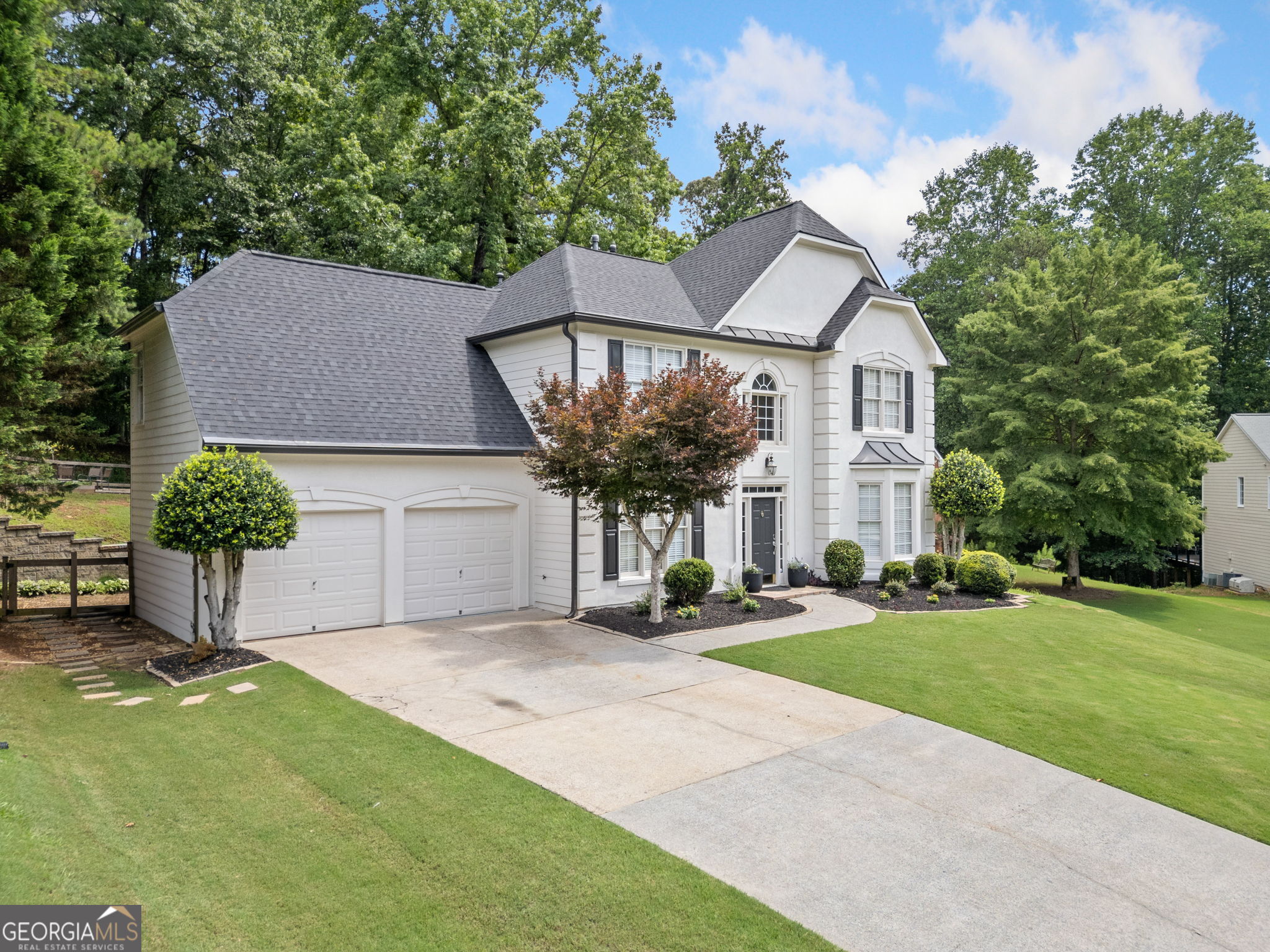 Discover a rare blend of comfort, updates, and natural beauty in this beautifully maintained home, ideally located on a quiet cul-de-sac in the highly sought-after Wyngate community. The property backs directly to over 17,000 acres of undisturbed federal land owned by the U.S. Army Corps of Engineers, which stretches all the way to scenic Lake Allatoona. Enjoy unmatched privacy and direct access to wooded nature right from your backyard. A welcoming exterior features a two-year-old architectural roof, durable HardiePlank siding, and clean landscaping that sets the tone for what's inside. Step through the two-story foyer into a bright, open layout with new hardwood floors that continue throughout the main level. The main floor includes formal living and dining rooms accented with detailed trim, along with a spacious family room featuring a fireplace and custom built-ins. The updated kitchen offers white shaker cabinetry, solid-surface countertops, stainless steel appliances, a center island, and a sun-filled breakfast nook that overlooks the backyard-perfect for staying connected with guests or family while cooking. Upstairs, the oversized primary suite features a tray ceiling, walk-in closet, and a private bath with dual vanities, a soaking tub, and a separate shower. Three additional bedrooms share a well-appointed hall bath, and the upstairs laundry room adds everyday convenience. Step outside to an oversized patio that's ideal for grilling, dining, or simply enjoying the peaceful views and occasional deer sightings. The fully fenced backyard offers ample space for gardening or play and backs directly to protected forestland with access to the lake. Wyngate is a vibrant, amenity-rich community featuring two swimming pools, tennis and pickleball courts, a basketball court, playground, and an active swim team with events throughout the year. With easy access to downtown Woodstock, downtown Acworth, The Outlet Shoppes of Atlanta, and top-rated schools, this home truly offers the best of location, lifestyle, and livability. Don't miss your chance to own this exceptional cul-de-sac property-schedule your private showing today.