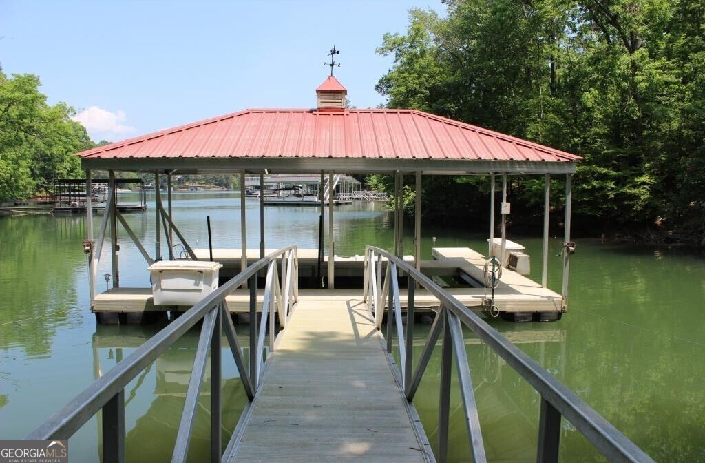 Lakefront Lot in Exclusive Gated Community! Don't miss this rare opportunity to own the last buildable lake lot in one of the most prestigious gated communities on the lake. This beautifully situated 1.37-acre lot is nestled in a calm, protected cove-perfect for swimming, boating, and year-round family enjoyment. The community features just 43 custom-built luxury homes and offers top-tier amenities, including a clubhouse, pool, tennis courts, pickleball, and a scenic outdoor recreation area. Included with the lot is a premium all-aluminum, hip-roof two-slip dock-a significant value and ready for immediate use. Whether you're ready to build your dream home now or hold this gem for future plans, this is a rare chance to invest in lakefront living at its finest!