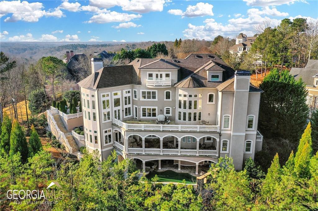 This exquisite European 18,000 sq. ft. home sits on the highest elevation in Country Club of the South. It offers magnificent unobstructed vistas for miles. The home was custom designed with five expansive and unique floors all served by a 5-story full-size elevator making complete access just a push button away. From the sky loft to the ultra-private saltwater pool and spa and outdoor kitchen make this home an entertainers dream. This home offers so much in luxury living its hard to envision. The $200,000 bronze-sculpted fountain is the focal point for the entry courtyard leading to a majestic column 25' high covered entry. From the moment you enter its high quality fit and finish is clearly evident at each unique level, enhanced by stately and impressive walls of glass flooding natural light throughout. The two-story library is a work of art, located just off the foyer. The home features three kitchen, three laundry rooms, three steam saunas, a home theater that is 2nd to none, wine cellar, and a spectacular indoor 3/4 professional basketball court, exercise gym, multiple bars, card room, 7 fireplaces, outdoor balconies for huge parties, and the list is seemingly endless! Come join us to tour this home truly built for the lifestyle you desire.