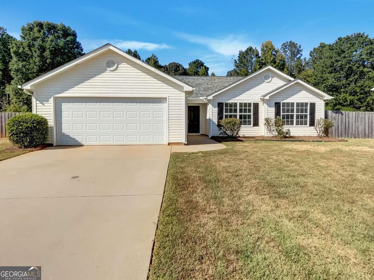 Discover this inviting 3-bedroom, 2-bath ranch on a generous half-acre lot in Covington, offering the perfect blend of comfort, updates, and convenience-all with no HOA. From the moment you step inside, the vaulted family room with a cozy fireplace sets a warm and welcoming tone, creating a perfect gathering space that flows seamlessly into the dining area. The kitchen features bright white cabinetry and stainless steel appliances, providing a clean, modern feel with plenty of space for everyday cooking or entertaining. The primary suite is a peaceful retreat, complete with a tray ceiling, spacious walk-in closet, and a private bath featuring a double vanity, separate soaking tub, and shower. Two additional bedrooms share a full bath, making them ideal for family, guests, or even a home office. Step outside to enjoy the patio overlooking a large, level, fenced-in backyard. Whether you're hosting a cookout, letting pets run freely, or enjoying quiet evenings outdoors, this backyard offers plenty of possibilities. The property also includes two storage sheds, providing ample space for tools, lawn equipment, hobbies, or even a small workshop-an added bonus for homeowners needing extra room. This home has been thoughtfully updated with a new water heater, fresh interior paint, and new LVP flooring, giving it a move-in-ready feel with modern touches. All of this is located just minutes from Downtown Covington, where you can explore local shops, restaurants, and entertainment, while still enjoying the privacy and space of your own property.