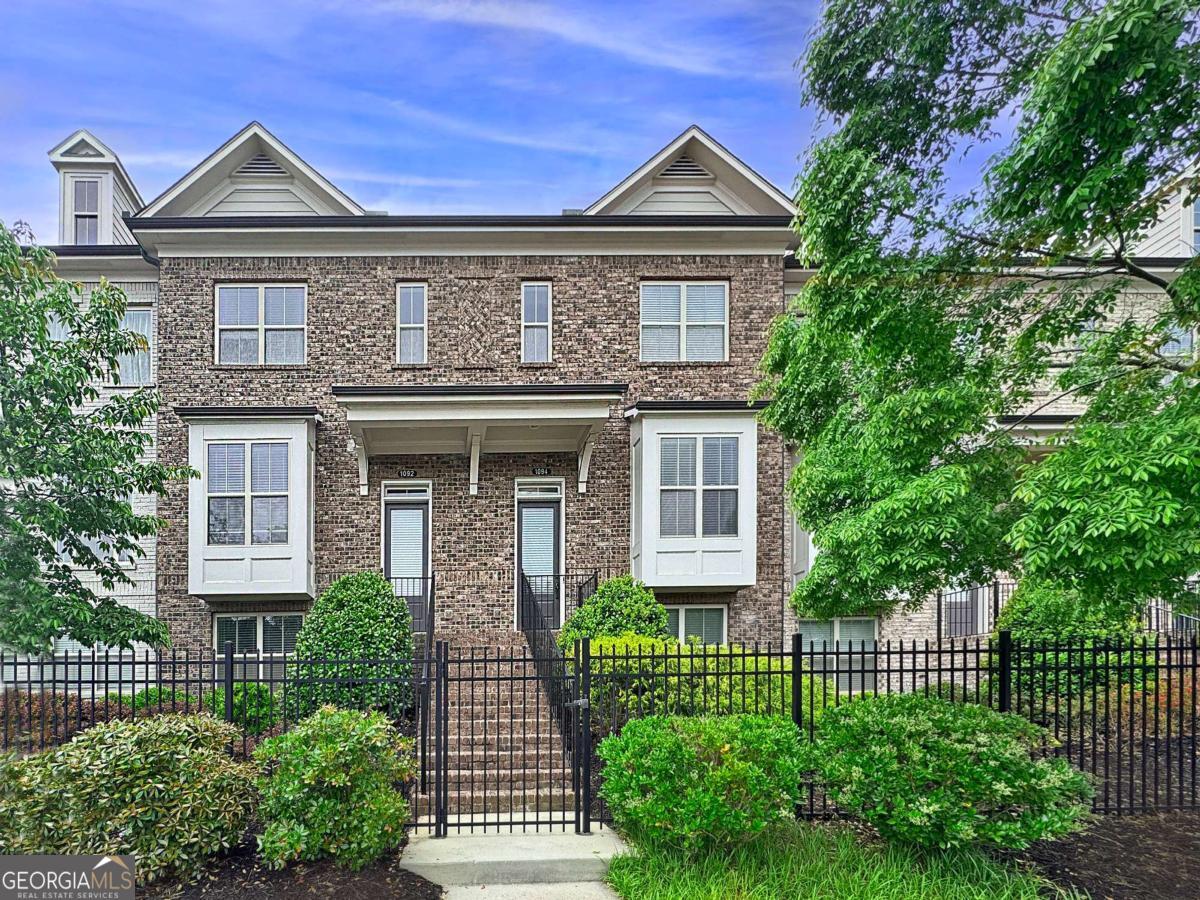WELCOME HOME to this beautiful, updated 3 bed, 3.5 bath brick townhome in the private East Roswell gated community of The Towns at East Village! This well-maintained, move-in ready home features a light and open floor plan, on-trend light oak hardwood floors, and updated finishes throughout! The main living level offers a formal dining area, spacious kitchen complete with breakfast bar, granite countertops, and stainless appliances, all open to the adjacent breakfast area, fireside family room, and convenient bonus room- perfect for a home office or play space. A private deck on the main level provides a great space for grilling out or dining al fresco! Upstairs, you'll find a spacious guest bedroom with ensuite bath, as well as the oversized primary bedroom with large walk-in closet, and updated ensuite bath with double vanity and large walk-in shower. The lower level includes a sizable private guest bedroom with full bathroom, and the rear two-car garage. The community is just a short distance to restaurants, schools, East Roswell Park and public library, Chattahoochee River Parks, trails, and more! Easy access to GA400 and Peachtree Industrial. Hurry! This one won't last!