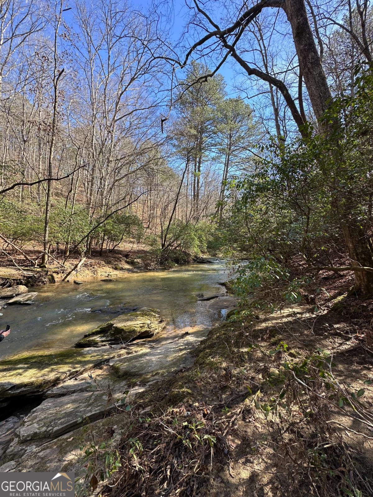 Beautiful Creekfront 1.56 Acre Lot with over 400 feet of River Frontage on Faucett Creek! (A double lot combined into 1) Quiet Cul-de-sac close to gated entrance of Mountain Creek Hollow Subdivision, home to many upscale homes and beautiful mountain lots. Location convenient to quaint town of Talking Rock between Jasper and Ellijay and just minutes from the areas famous wineries. The neighborhood has paved roads and community water. Amenities include community pavilions with fireplaces, picnic tables, nature walking paths, beautiful gated and landscaped entrance with water feature, covered bridge, and natural waterfalls. Short term rentals not allowed. ** owners are licensed real estate agents in the state of Georgia.