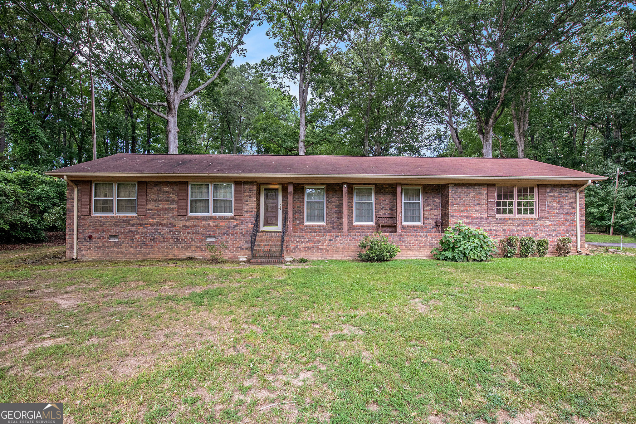 Discover the potential of this classic 4-sided brick ranch home, peacefully situated on 2.31 acres of picturesque land. This 3-bedroom, 2-bath residence offers a solid foundation with timeless construction and is ideal for those seeking to customize a home to their own tastes. The inviting family room features a traditional brick fireplace, providing a warm and welcoming focal point and is open to the cute eat in kitchen. The front of the house has a more formal living room and dining room combination with large windows. A spacious screened-in porch overlooks the expansive and private backyard, offering the perfect space for outdoor enjoyment in any season. Additional features include a 2-car carport and a private well, adding both convenience and value. With a bit of updating and care, this property presents an excellent opportunity to create a beautiful home in a tranquil setting.
