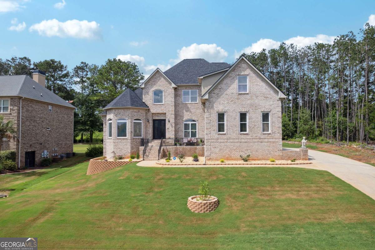 Experience elevated living at 2548 Westchester Way SE, a stunning and thoughtfully updated four-sided brick home located in the prestigious Westchester Lakes community. This custom executive residence is situated on a beautifully landscaped 1-acre lot and showcases a seamless blend of classic elegance and modern luxury. Step inside to discover soaring ceilings and expansive windows that flood the home with natural light, creating a bright and airy atmosphere throughout the main living areas. The open-concept floor plan offers a perfect balance of comfort and sophistication. The spacious gourmet kitchen is a true chef's delight-complete with marble flooring, high-end stainless steel appliances, custom cabinetry, and a large center island ideal for entertaining or casual family dining. The main-floor owner's suite is a luxurious retreat featuring a cozy fireplace, sitting area, and large windows overlooking the backyard. The spa-inspired en-suite bath boasts a deep soaking tub, a separate glass-enclosed shower, dual vanities, and elegant finishes, offering the perfect escape at the end of the day. Upstairs, you'll find three generously sized guest bedrooms, providing comfort and privacy for family and visitors. Notably, one of the upstairs bedrooms features its own en-suite bathroom, perfect for a teen suite or private guest quarters. The additional bedrooms share a full bath and offer abundant closet space. The fully finished basement expands the home's versatility and value, featuring two additional bedrooms, ideal for extended family, guests, or home offices. This level also includes a state-of-the-art home theater, a fully equipped gym, and a large recreation/game room, offering space for relaxation, fitness, and entertaining. Step outside to a serene backyard oasis, offering privacy and room to play, entertain, or even add a pool. As part of the Westchester Lakes community, you'll enjoy access to pristine lakes, a sparkling swimming pool, tennis courts, and scenic walking paths-perfect for active lifestyles and peaceful moments alike. Conveniently located near top-rated schools, shopping, dining, and the vibrant downtown area of Conyers, this exceptional home combines luxury, comfort, and lifestyle in one remarkable package. Don't miss your chance to own this beautifully upgraded executive home in one of Conyers' most desirable neighborhoods-schedule your private showing today!