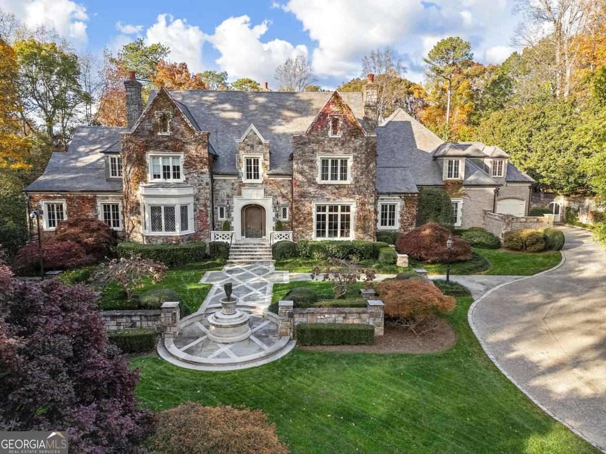 Set on an expansive three-acre private estate in Atlanta's exclusive Paces Ferry neighborhood in Buckhead, this stunning custom stone English manor, designed by renowned architect William T. Baker and built by custom builder McGarity.Timeless elegance combined with modern sophistication. Exceptional value at this price and available now. This gated property set way back from the street with a sweeping drive leading to a meticulously designed motor court and four-car garage, ensuring plenty of parking options. The interiors finishes are a testament to exceptional craftsmanship, beginning with the grand two-story foyer, where oak paneling and marble floors set a luxurious tone. To the left, an elegant study with fireplace provides a refined retreat. To the right, is a formal living room with fireplace or seating area. The heart of the home is the chefs kitchen and separate catering prep kitchen. Featuring two expansive islands clad in marble, professional-grade appliances, and dual pantries - including a butlers pantry - designed to make entertaining seamless. This space flows effortlessly into the spacious family room, complete with soaring vaulted ceilings, a cozy fireplace, and an adjacent sunroom that invites natural light and views of the lush surroundings. A standout feature is the glass conservatory, imported from England, offering a serene space to enjoy the gardens year-round. The main-level primary suite is a private sanctuary, complete with a sitting area, fireplace and overlooking the pool.  Two separate generously sized dressing rooms. Upstairs, four additional bedrooms, each with en suite bathrooms, provide ample accommodations for family and guests. A versatile bonus room and an elevator that accesses all three levels add to the homes functionality. Whole house generator, upgraded integrated lighting and security system. The terrace level is designed for recreation and relaxation, boasting a billiards area, full bar, wine cellar, fitness center, sauna, and a state-of-the-art movie theater. Outside, the grounds, envisioned by famed landscape architect John Howard, offer a resort-like experience. Enjoy lush, professionally curated gardens with over 70 specimen Japanese Maples, a sparkling pool with a hot tub, an open-air summer pavilion, and a dedicated play area with playhouse.  This 3 acre estate offers unparalleled access to Buckhead premier shopping, dining, and some of the cities top public and private schools. Own  a legacy property blending classic sophistication with modern amenities in one of Atlanta's most sought-after locations.