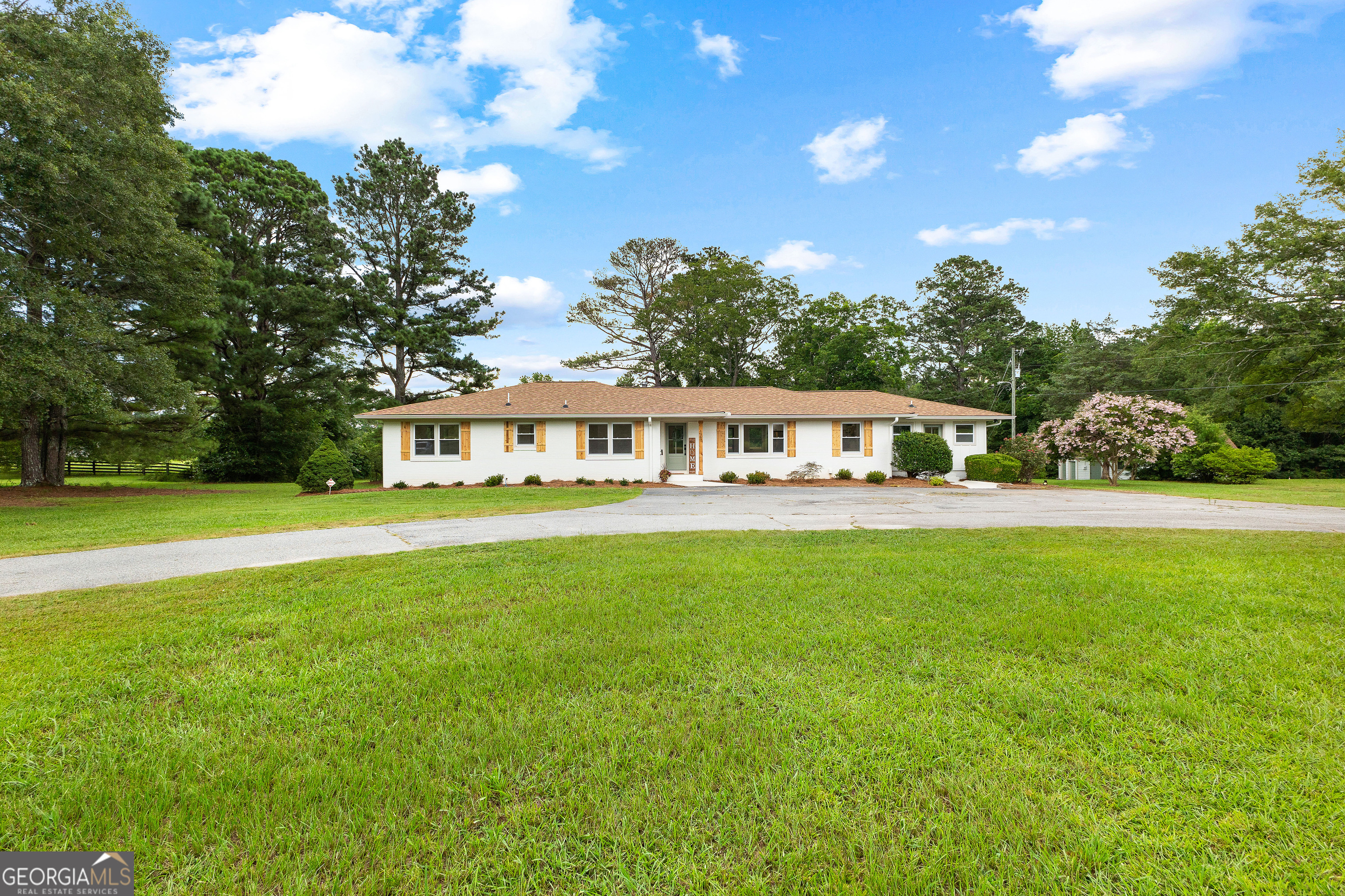 Beautifully remodeled 4-sided brick ranch on 5 private acres in Coweta County! This 3 bed, 2.5 bath home offers the perfect blend of classic charm and modern upgrades. Step inside to an open-concept great room with a stunning kitchen featuring a large island, soft-close cabinetry, all-new appliances, and extra shelving. Around the corner, you will find a walk-in pantry with pull-out shelving. The spacious mud/laundry room includes two side entrances, additional cabinetry, and tons of storage. Relax outdoors on the expansive back deck surrounded by mature trees, perfect for your morning coffee or evening unwind. Unfinished daylight basement provides future expansion potential. A detached 20x40 garage (built in 2000) offers power on a separate meter, a large floored upper-level loft area, and endless possibilities-ideal for a workshop, studio, or guest space. Roof is only 3 years old. Truly a rare find with space, privacy, and thoughtful updates throughout!