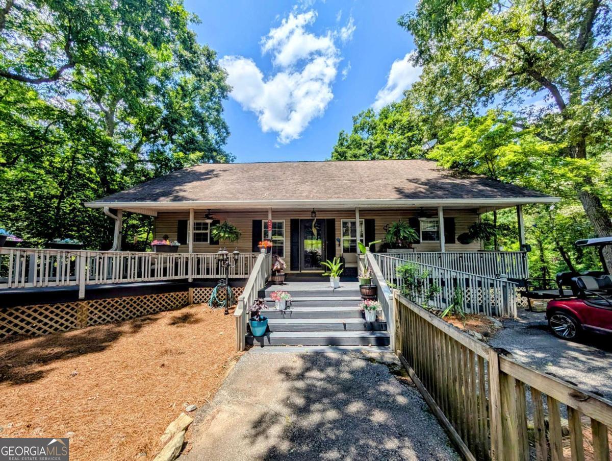 THREE HOMES IN ONE! Welcome to 95 Windjammer Drive, a rare multi-residence property in the Windjammer lakeside community of Hiawassee, Georgia. Perfectly positioned to capture peaceful, year-round lake and mountain views, this fully furnished retreat offers the perfect combination of comfort, privacy, and versatility-ideal for full-time living, vacation use, or rental income. The primary home features 1 bedroom and 1 bathroom on the main floor, along with a cozy fireplace in the living room, a spacious kitchen, sunroom, expansive porches and decks, and a charming gazebo-creating the perfect setting for relaxing or entertaining. A fenced-in yard provides a safe and enjoyable outdoor space for pets. The finished basement serves as a separate living area, complete with 2 bedrooms, 1 bathroom, a partially finished kitchen, a laundry area, and a private patio with a hot tub. Adjacent to the main home, the garage apartment is a fully independent residence offering 1 bedroom, 1 bathroom, a full kitchen, laundry area, and a two-car garage-an excellent option for long-term rental income, guest accommodations, or multi-generational living. Situated on a paved road in a well-established community, this property represents a truly unique opportunity to own a flexible, possibly income-generating home in the beautiful North Georgia Mountains. Call us to schedule your private showing today!