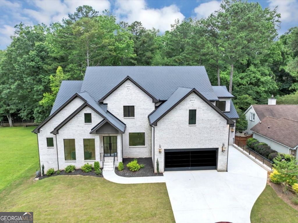 Welcome to your dream home in the sought-after Indian Hills community, ideally situated in East Cobb within the top-rated Walton High School district. This newly constructed, all-brick custom estate features 5 spacious bedrooms, 5.5 bathrooms, and a 3-car garage with sleek custom glass-and-steel doors. Inside, enjoy sun-drenched interiors, designer finishes, and oversized windows that flood the home with natural light. The covered rear porch with fireplace and the private backyard are perfect for entertaining, from intimate family gatherings to grand celebrations. The open concept main level features a state-of-the-art chef's kitchen with double islands, breakfast area, family room, keeping room, formal dining room, home office, mudroom, and powder room. The master on main main level suite with spa-inspired bath showcases a free-standing soaking tub, double vanities, expansive shower, and dual custom walk-in closets with pull-down hanging system and drawer storage. Upstairs offers a versatile flex space-ideal as a second living room, playroom, or media lounge-alongside four generously sized secondary bedrooms, each with its own private en-suite bath. The boutique-style laundry suite completes the upper level. The terrace level hosts a patio and unfinished daylight basement stubbed for plumbing and electric, providing a blank canvas for future customization and expansion. This home features four fireplaces, smart toilets, custom closets, a dry bar, two pantries, high-end appliances, ambient rope lighting, soaring ceilings, and handcrafted custom cabinetry-all set against pristine White Oak flooring. From the striking entrance to the extra-wide hallways, every inch has been thoughtfully designed to elevate your lifestyle and sets the stage for hosting distinguished guests or relaxing with family. Don't miss the opportunity to make this extraordinary property your Home Sweet Home! Schedule your private showing today.