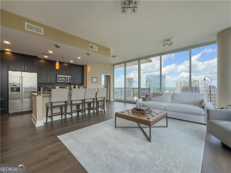 Welcome to luxurious living in the heart of Midtown! This outstanding location is just a short walk from Piedmont Park, the Beltline, the Fox Theater, the Atlanta Botanical Garden, and the High Museum of Art. Enjoy stunning views of the city's skyline & breathtaking sunsets from every room on the 28th floor. This spacious condo features 2 bedrooms, 2 bathrooms, and walk-in closets. NEW hardwood floors and fully renovated 2nd bathroom. The roommate-style floor plan ensures privacy while offering impressive views all around. The open-concept living area seamlessly connects to a gourmet kitchen equipped with top-of-the-line stainless steel appliances. Building amenities include a heated saltwater pool, fitness center, club room, 24/7 concierge service, a recently renovated SkyPark, gas grills, and a fire pit. This unit comes with TWO assigned parking spots for your convenience.