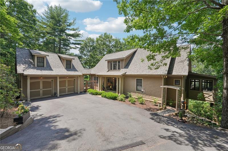 Stunning Chestnut Hill Plan with Panoramic Mountain Views in Big Canoe Step into timeless Southern charm with this beautifully crafted Chestnut Hill home, perfectly positioned to capture sweeping mountain views through walls of windows. Located in the prestigious gated community of Big Canoe, this residence blends architectural elegance with thoughtful functionality. The spacious main-level family room features a soaring stacked stone fireplace and custom built-ins, creating a warm, inviting gathering space. It flows seamlessly into the gourmet kitchen, complete with high-end finishes, generous workspace, and a well-planned layout ideal for both cooking and entertaining. The adjoining dining area opens to an Eze-Breeze screened porch and a side deck, perfect spots to soak in the surrounding natural beauty year-round. The main level owner's suite includes a serene sitting room and a luxurious, spa-inspired bath. Upstairs, you'll find two additional bedroom suites and a cozy loft, offering privacy and comfort for guests or family. The terrace level boasts a second fireside family room that opens onto a large deck and screened porch. An additional guest bedroom with full bath ensures plenty of space for visitors. Also on the terrace level: an impressive, fully equipped woodworking workshop with a half bath and ample storage. Additional Features: Detached garage with finished, climate-controlled bonus space above, ideal for an office, studio, or man cave Newly replaced roof for peace of mind Main-level Trex decking for low-maintenance outdoor living Home generator Central Vac Lightening protection AHC home warranty Exceptional craftsmanship and detail throughout This exceptional home offers a rare combination of craftsmanship, comfort, and breathtaking views in one of North Georgia's most desirable mountain communities.