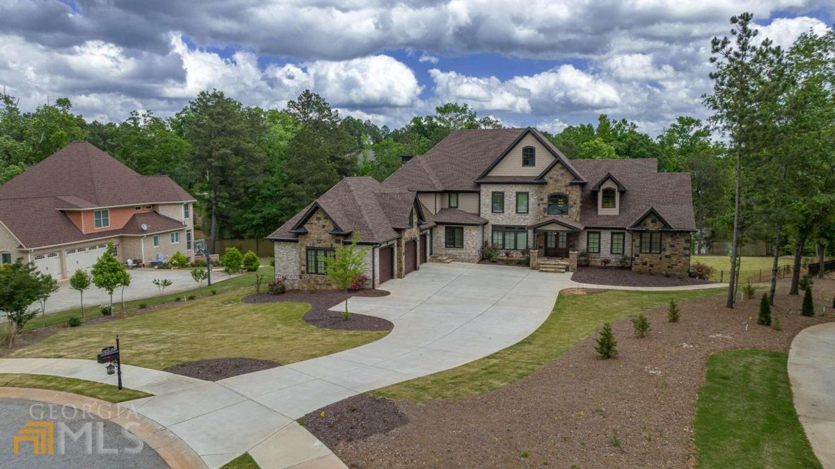 Picture yourself rushing home every evening to your own private oasis in North Oconee! Enter the oversized double front doors of this custom-built masterpiece to a grand entry foyer. Enjoy both entertaining and everyday living in the chef's kitchen, complete with premium custom cabinets, Thermador Appliances, expansive island with prep sink and wine rack, 6 burner gas cooktop with decorative vent hood and pot filler and an oversized walk-in pantry with wood shelving and granite countertops. The kitchen easily flows into the Great Room creating the perfect open living space. The mudroom and laundry room are combined to make organization a breeze and is conveniently located right off the 3-car garage. Rounding out the living area on the main level is a formal dining room and private office with barn doors. The owner's suite is truly a retreat, tucked away in a private corner of the main level. The bedroom itself is oversized with its own covered porch and two separate walk-in closets. The owners bath features a vessel tub and spa shower with frameless glass enclosure. The main level also includes a guest bedroom with a private bath and an additional conveniently located half bath. Walk up the floating staircase to find 4 spacious secondary bedrooms, each with a private bath with tiled, frameless shower and walk-in closet. A second staircase leads to the terrace level complete with a king-sized bar and plenty of living space for a seating area and separate gaming area. In addition, this level features a private gym, a half bath, plenty of storage space and second mudroom and full bathroom convenient to the pool and outdoor retreat. As you exit the terrace level, no detail was overlooked in completing this backyard paradise. Including ample space for entertaining, a freeform pool, jacuzzi, stacked stone waterfall and fire pit. A spiral staircase leads you to a second covered porch right off the kitchen. This distinctive home is less than 2 years old, everything you could want and so much more!