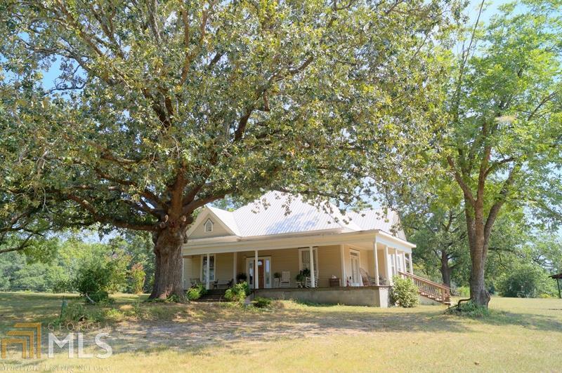 QUIET COUNTRY SETTING - CHARMING, CIRCA 1900 FARM HOUSE ON 5 ACRES! Take a step back in time when visiting this home. A 100+ year old oak tree greets you as you ascend the front steps and walk onto the large front porch. Original hardwood flooring & mouldings throughout the home. Gorgeous fireplaces in nearly every room give a nostalgic feel. Formal living room and den have lots of windows. Eat-in kitchen with island leads to the large laundry room. Cozy screened porch as well as a sunroom overlook the acreage. Bead board ceiling in first bedroom & behind drop ceiling in remainder of rooms. Several storage buildings including a workshop. Updated electrical, plumbing, and HVAC system. Lifetime metal roof in 2005.