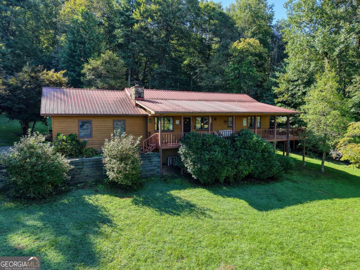 This stunning two-bedroom, two-bath country rustic home sits on 17.34 private acres and directly adjoins U.S. Forest Service land, offering endless opportunities to explore and enjoy the outdoors. From the moment you arrive, the charm is undeniable with both a covered front porch and an open porch, perfect for soaking in the peaceful surroundings. Inside, the spacious open-concept design seamlessly connects the kitchen, dining, and living areas.The living room features a cozy wood-burning fireplace, while the kitchen boasts beautiful quartz countertops and plenty of space for entertaining. Step outside, and you'll discover creek frontage and year-round, long-range mountain views that are nothing short of breathtaking. A private well ensures reliable water, and the property includes a two-car garage for convenience. Whether you're relaxing on the porch, enjoying the warmth of the fireplace, or exploring the land that stretches right into the national forest, this property offers the perfect blend of comfort, privacy, and natural beauty.