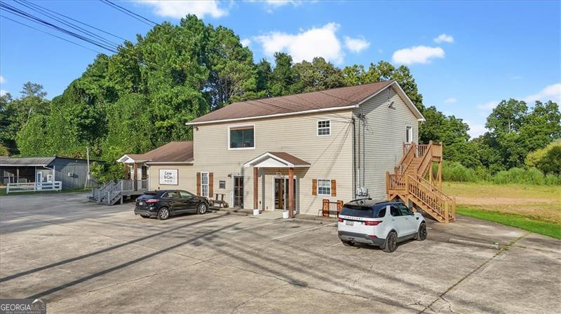 Commercial Building for sale with an acre+ lot in Prime location in Ball Ground! The property consists of two large spaces that each have their own entrances/exits and bathrooms. The rest of the building is 7-8 office spaces, entrance foyer/lobby to welcome all clients, two bathrooms, areas for storage and a separate exit. Ample parking for all businesses. The property is on sewer. The land on the side and rear of the building has been cleared and could be fenced in to allow for additional income to be produced. A survey is available.