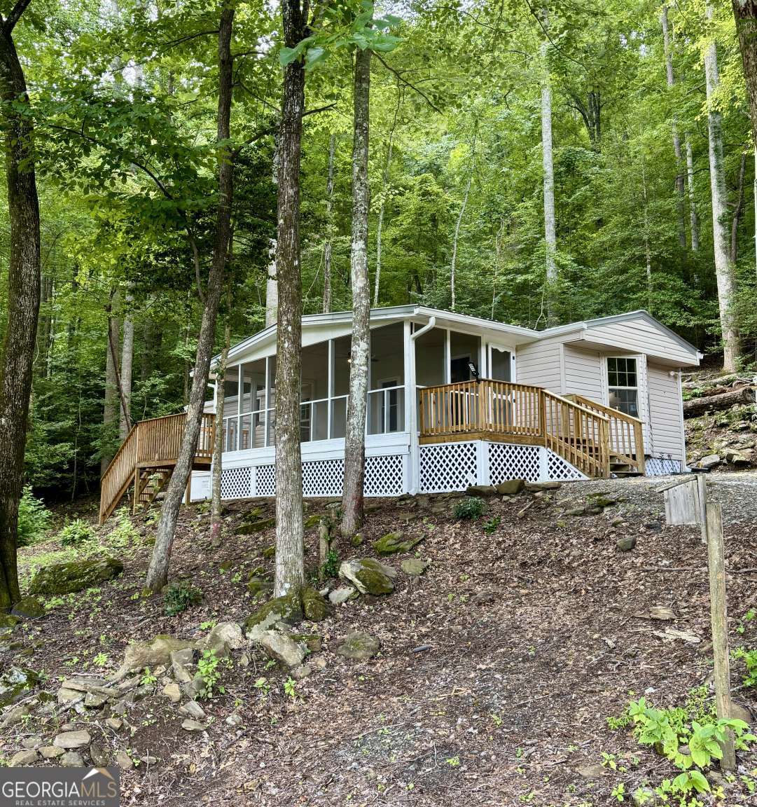 Updated 3BR/2BA home in a great Hiawassee location with seasonal long-range mountain views. Nearly everything is new-flooring, light/plumbing fixtures, vanities, cabinets, countertops, windows, paint, roof, and a 1-year-old water heater. Enjoy mountain air from a huge screened front porch, plus two additional porches for entertaining. Perched at the crest of a hill, this move-in ready home offers charm, comfort, and affordable mountain living.