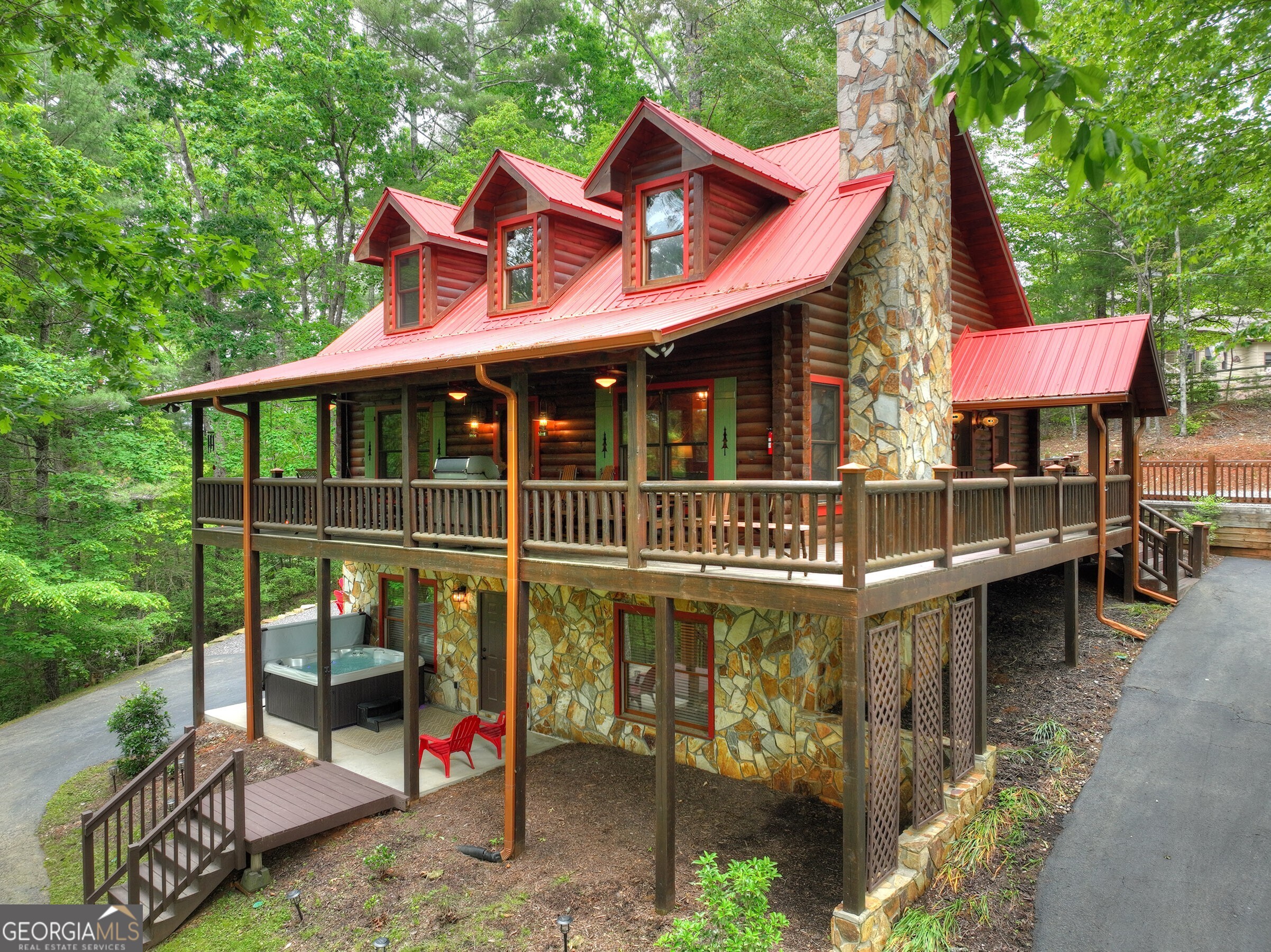 Located in the desirable, gated community of Goose Island Hideaway, this FULLY FURNISHED cabin makes for a perfect full-time residence, second home, or rental investment. Cabin was professionally decorated and furnished in 2023. Conveniently located between Blue Ridge and Ellijay, only a couple miles off the main corridor (SR 515)- everything is just a short ride away. As you cross the covered bridge over the Ellijay River, the fully paved streets leading up to this true log cabin are nothing but inviting. Complete with three full bedroom suites, an additional fourth bunk room loft/game room, an open-concept floor plan features soaring ceilings with impressive beam work, an entertainer's kitchen, and ample outdoor living areas. This custom cabin was built with quality in mind. From the live edge wood staircase, the hand turned bannisters, granite countertops, and whole home generator - no expense was spared. The recently finished lower level includes a game room, wet bar, hot tub, and a custom glass door that opens to the impressive firepit area complete with magical string lighting. This private, wooded oasis is located near the Benton Mackaye Trail and other highly sought-after hiking and biking areas. Call today for an exclusive tour and experience the mountain life as it should be lived.