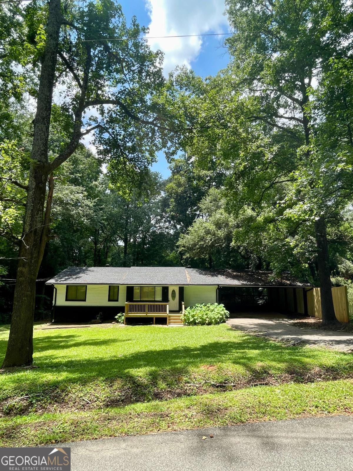 Clayton County Privacy and Convenience! Newly renovated and MOVE-IN-READY! Easy access to Panola Rd/I675. +- .40 ACRE of PRIVACY. This renovated, 4 bedroom/ 2 full bath home features beautifully refinished floors throughout. ALL NEW kitchen granite, backsplash and NEW appliances. New bathroom flooring, vanities, shower tile and toilet. Full length dining room/flex space off the kitchen with new french doors leading to the covered patio. NEW front deck. Very private back yard could be your private oasis in waiting! Full bath and potential second living space in the lower level with separate entrance. Large bedroom and TONS of storage downstairs. OVERSIZED, two area ATTACHED shop space offers two points of exterior entry and SO MUCH POTENTIAL for a home business! EXTRA WIDE covered parking. NO HOA on this quiet street with only a few private residences. No exit access, dead end street. Nice residential area to call home!