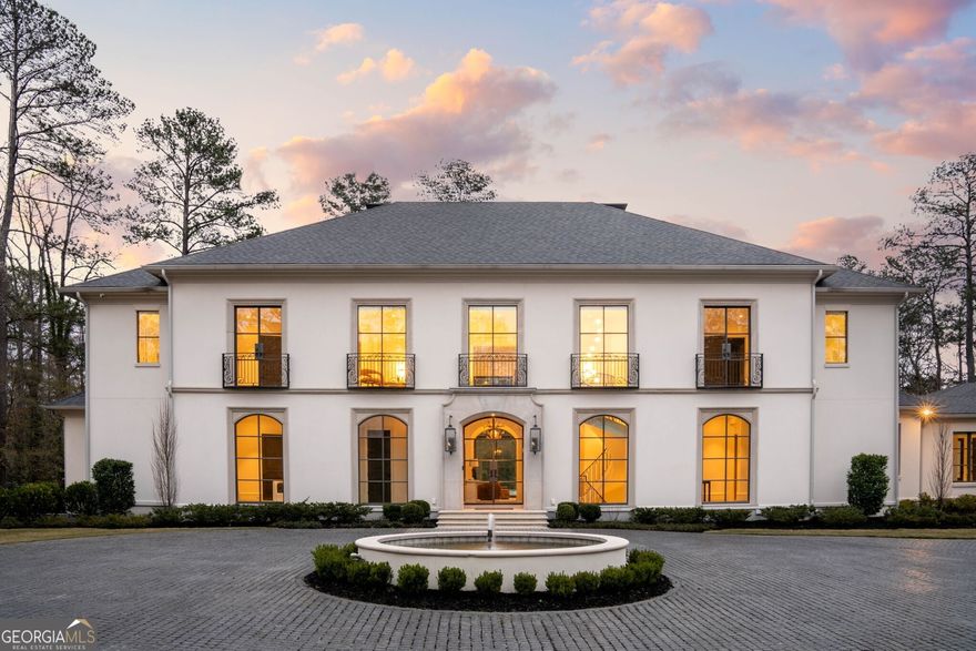 Welcome to an unparalleled living experience at this breathtaking European-inspired estate, perfectly positioned on 2+/- private acres. This exquisite custom designed residence by Harrison is the epitome of luxury, where thoughtful architectural design, meticulous craftsmanship, and premium materials come together in perfect harmony. Step into a world of elegance from the moment you enter, with a dramatic floating stairway, bespoke millwork, and iron windows that invite an abundance of natural light into every room. The wide plank oak flooring adds warmth and character, creating an inviting ambiance that seamlessly flows throughout the home. Each space is meticulously crafted, with multiple arched openings and custom lighting enhancing the luxurious yet functional design. Designed for the ultimate entertainer, the open-concept great room is a true showpiece, anchored by a floor-to-ceiling wall of iron windows that create a stunning connection to the outdoors. Enjoy the tranquil beauty of the expansive turfed backyard, featuring a heated saltwater pool, spa, sun deck, and a covered fireside entertainment space perfect for year-round enjoyment. The heart of this home is the chef-inspired kitchen, boasting a striking 10-foot granite waterfall island, top-of-the-line appliances, and a hidden walk-in pantry. Accordion windows open up to the covered outdoor space, bringing the outdoors in and making al fresco dining a breeze. Retreat to the luxurious primary suite, designed to be a sanctuary of relaxation. A cozy bay window sitting area, two walk-in closets, and a spa-like marble-clad master bath with heated floors, a walk-in steam shower, soaking tub, and twin floating vanities create the perfect environment for unwinding. For family, guests or live-in help, a separate residence was thoughtfully curated with a private entrance that offers a luxurious retreat exemplifying the finest of details, complete with views of the pool and an elevator. A spacious 4-car garage, a state-of-the-art Savant home automation system, and electronic shades throughout both homes elevate the modern living experience. The finished terrace level provides endless possibilities, including a massive recreation room, workout space, and ample room for expansion, with the potential to add a theater, wine cellar, or additional bedrooms. Ample space for a basketball, pickle ball or tennis court. This estate is more than just a home - it's a lifestyle, offering unmatched elegance, privacy, and luxury. Experience the very best of Atlanta living in this one-of-a-kind residence.