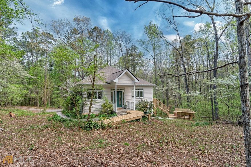 You will find tranquility and relaxation in this home in a gated private community. Nestled on 5 private wooded acres just minutes away from dining and shopping in Roswell and Woodstock. So much love and attention made this home a warm, functional, inviting space. Once inside, you will be bathed in sunlight and have views of nature all around. You'll enjoy making family meals in this spacious kitchen with an abundance of cabinets and a pantry. Right off the kitchen is a screened-in porch perfect for sipping your morning coffee or tea. In the evening, you can relax by the wooded fire pit on the side deck with friends and family. Additional features of this home include a full unfinished basement plumbed for kitchen and bath, a workshop, ceramic wall heaters throughout, and solar tubes in the kitchen and guest bath, new roof, newer carpet, and luxury vinyl. Buyers can receive up to $3000 in closing cost by working with our preferred lender Lisa Dillion at Supreme Lending.