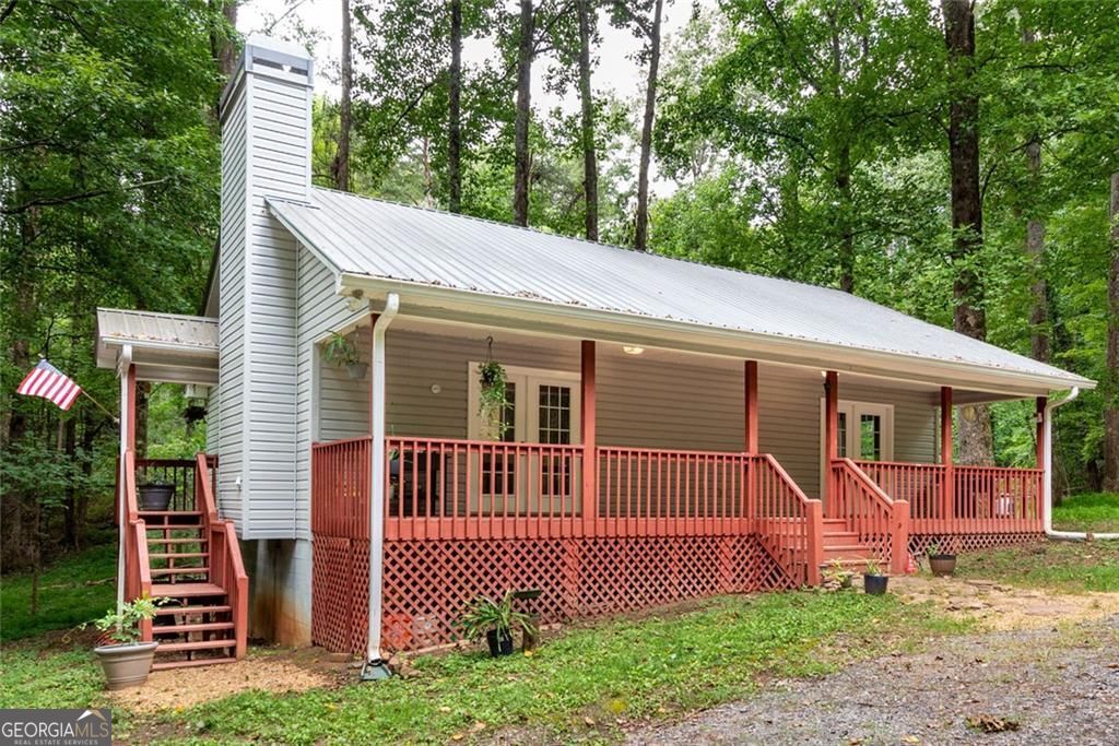 Charming Home on 3 Private Acres in Hickory Cove | Close to Downtown Jasper. This GEM is nestled on a beautiful, wooded 3-acre lot in the Hickory Cove neighborhood-just 4 miles from downtown yet worlds away in privacy and serenity. No HOA. Built for easy maintenance, the home features vinyl siding, a metal roof, and a welcoming full-length front porch-where you can watch deer, turkey and other wildlife. The level driveway offers ample parking and room to build a garage or workshop if desired. Inside, you'll find an open floor plan with great natural light, thanks to glass French doors and a side door off the living area. The living room, dining space, and kitchen flow together seamlessly, centered around a cozy wood-burning fireplace with a gas starter. The home includes two bedrooms and two full baths. One bedroom features an attached bath, while the other offers direct access to the front porch via French doors. A hallway laundry closet and guest bathroom provide convenience and function. A ramp would be easy to add to one end of the front porch if needed. Additional value is in the 3 acre lot which is surveyed as one tract and also as two 1.5 acre lots. One could potentially be sold separately, another home built etc.. Enjoy nearby amenities including the neighborhood's private lake as well as the close proximity to downtown Jasper just minutes away. Whether you're looking for a full-time home, weekend escape, or investment opportunity, this property offers the space, location, and potential you've been looking for. On public water but there is also well on the property.