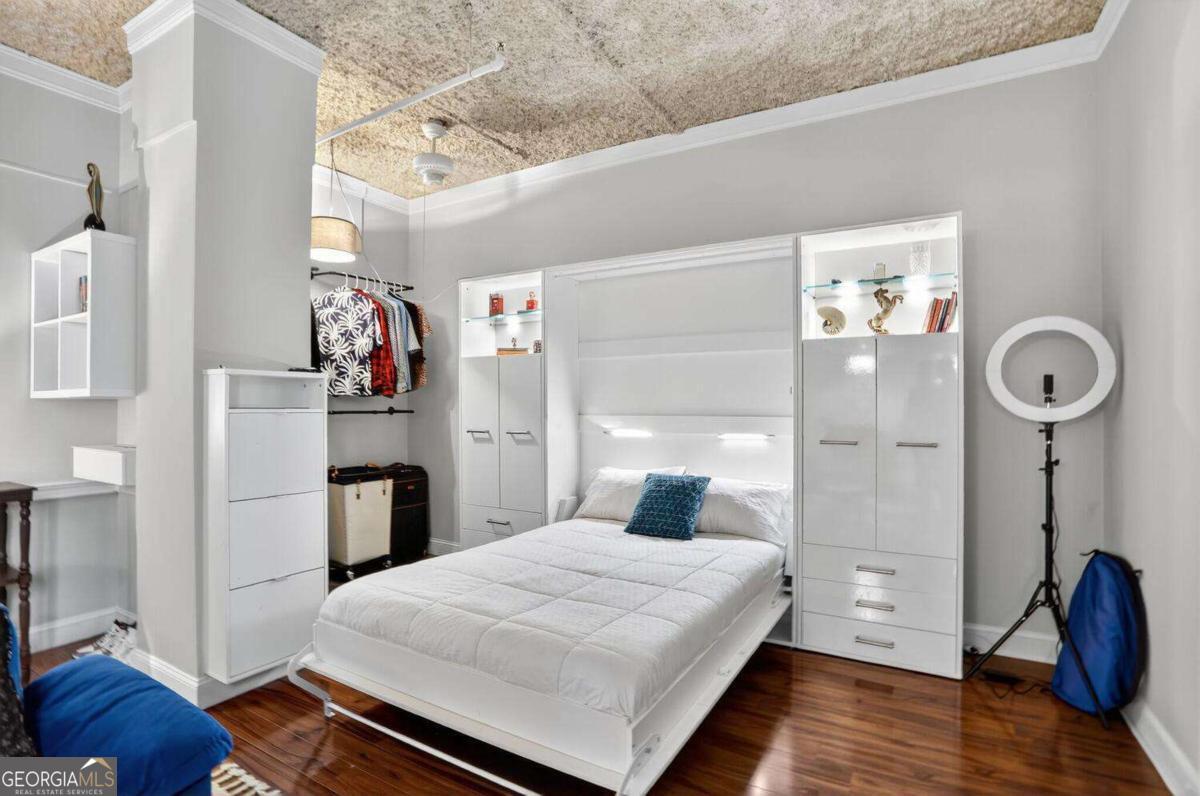 Penthouse-Level Living in a Storied Downtown Landmark, Perched on the penthouse level of The Metropolitan, this residence blends historic character in the vibrant heart of Downtown Atlanta - home to the 2026 FIFA World Cup at Mercedes-Benz Stadium. Originally built in 1911 as the Third National Bank Building, Atlanta's first true skyscraper, the structure later became the Atlanta Federal Savings and Loan Building before being reimagined in 1996 as loft-style condominiums. Today, residents enjoy the charm of exposed ductwork, soaring 10-foot ceilings, and oversized rotating windows that flood the space with natural light and showcase sweeping city views. Inside, the home has been refreshed with a sleek, contemporary paint palette and thoughtful design features. Hardwood floors and high ceilings create a polished, loft-like atmosphere, while a built-in Murphy bed maximizes space and flexibility for day-to-night living. An efficient and clean kitchen and bathroom complete the home's interior. The Metropolitan offers conveniences that make city living effortless. The HOA covers concierge, fitness center, and ground maintenance, giving residents peace of mind along with true lock-and-leave convenience. Additional amenities include a secured-access lobby, a well-equipped fitness center, on-site laundry, and a pet-friendly environment. Please note, the building is not FHA approved and has rental restrictions in place, making this an ideal home for professionals, students, or anyone seeking a prime location and stunning city views. Experience urban living at its finest, with attractions like Mercedes-Benz Stadium, State Farm Arena, Centennial Olympic Park, the Georgia Aquarium, the National Center for Civil and Human Rights, the College Football Hall of Fame, and The Tabernacle all just moments away. This location caters to a variety of lifestyles. For professionals on the go, Five Points MARTA Station is just minutes away, offering quick access to Hartsfield-Jackson Atlanta International Airport. Students will appreciate the short distance to Georgia State University, with Georgia Tech only a couple of miles down the road. Food lovers will delight in the abundance of dining options, pubs, clubs, parlors, and breweries nearby. Don't miss this opportunity to own a piece of Atlanta's history with all the conveniences of contemporary urban living - a penthouse-level residence that offers both the energy of the city and the comfort of home.