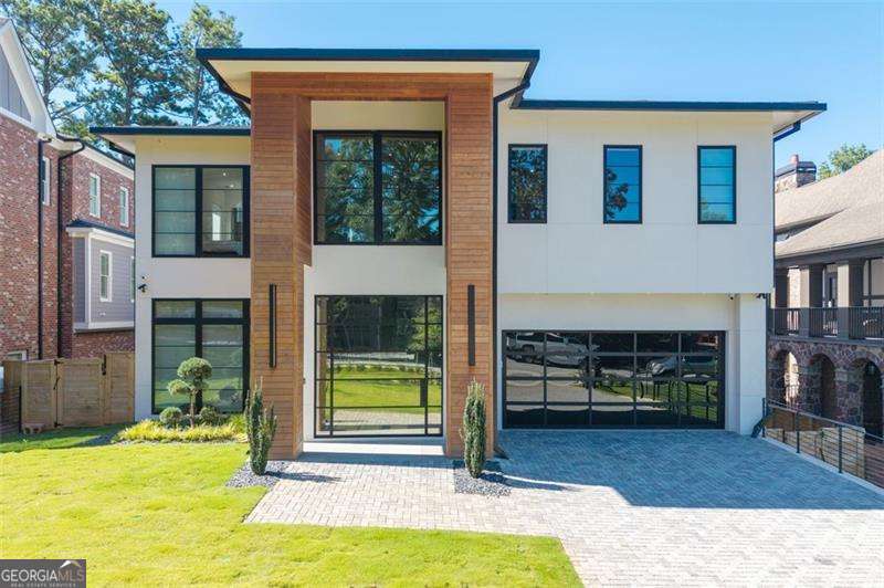 Experience the pinnacle of modern luxury in this I & G Builders architectural masterpiece featuring 5 bedrooms and 5.5 baths. Walls of glass invite in an abundance of natural light, seamlessly blending indoor and outdoor living while showcasing clean lines and refined design. The chef's kitchen boasts custom cabinetry, professional-grade appliances, and an oversized leathered soapstone island crafted for both function and style. Expansive living and dining spaces flow effortlessly, perfect for grand entertaining or intimate gatherings. Each bedroom offers a private en-suite retreat, with the primary suite serving as a sanctuary complete with a spa-inspired bath and boutique-style dressing room. Outside, a resort-caliber pool is framed by sleek terraces and lush landscaping, creating an idyllic setting for relaxation. Every detail of this residence exudes sophistication, offering a lifestyle defined by elegance, comfort, and distinction.