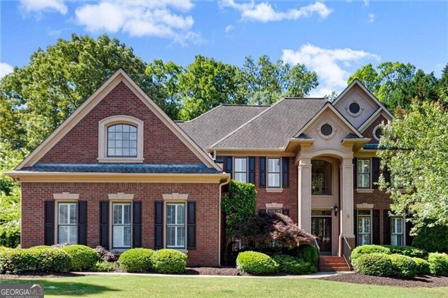 Welcome home to this beautifully maintained home located in the highly sought-after swim and tennis community of Hampton Hall in Alpharetta. Offering one of the largest floor plans in the neighborhood, this spacious four-bedroom, four full bathroom, and one half bathroom home sits on a generous 0.59-acre lot and is nestled within one of the area's top-ranked school districts.  From the moment you walk through the front door, you'll be greeted by an abundance of natural light and a thoughtfully designed layout that effortlessly blends everyday comfort with spaces ideal for entertaining. The main level features a formal dining room and office. The two-story main living area includes built-ins, a fireplace, and expansive windows that allow sunlight to flow throughout the home. The white kitchen features stainless steel appliances and a breakfast nook. This open-concept design flows seamlessly into a screened-in porch, where you can unwind and take in the peaceful, private backyard. Whether gathered around the fire pit or enjoying the tranquil water feature, the outdoor space is truly an extension of the home.  Upstairs, the oversized primary suite is a serene retreat with tray ceilings, rich hardwood floors, and large windows that fill the room with natural light. Three additional bedrooms and a spacious bonus room offer flexibility for growing families, guests, or a home office setup.  The fully finished terrace level is a standout, complete with a custom bar, a dedicated workout room, and a large playroom with a stage-perfect for everything from game nights to creative performances.  Hampton Hall is renowned as the premier swim/tennis community in the top-rated Johns Creek school district. It offers a variety of social activities, including a swim team, family events, four tennis courts, tennis teams, and a soccer field. The location is unbeatable! You can bike or walk to the Big Creek Greenway and Waters Road Park, and you're just minutes away from shopping, restaurants, recreation and nightlife in downtown Alpharetta, Avalon, Newtown Park, Ocee Park, and more! Don't miss your chance to experience the perfect blend of modern luxury and classic comfort in one of Alpharetta's most sought-after communities!