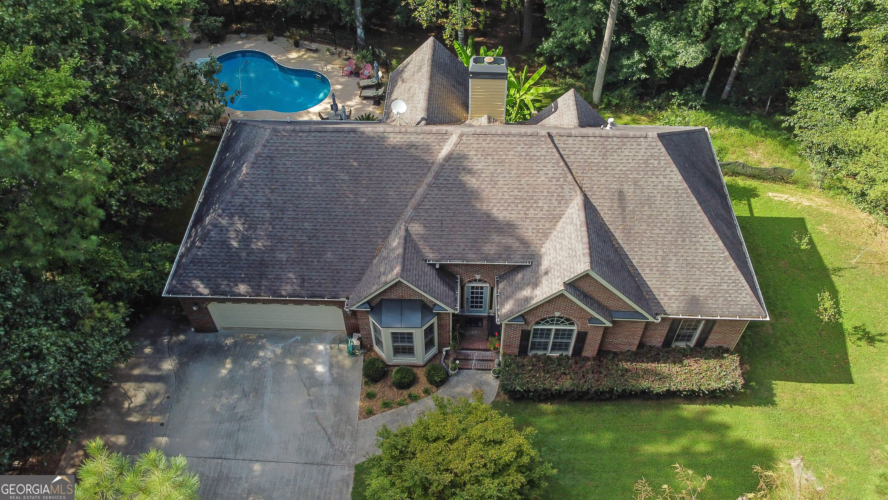 Welcome to your private oasis - where home feels like a vacation retreat! Stunning 3/3 ranch on a finished basement on 5 serene acres, offering everything you need for relaxation and entertaining. Enjoy an inground pool-updated liner (4 yrs), new motor (2025), a rebuilt hot tub (2024), and a tranquil koi pond with water feature, all surrounded by beautiful landscaping. A 12x30 outbuilding with electricity, skylights, and a thermostatically controlled fan, plus a 12x16 storage shed, provides plenty of workspace and storage. Inside, the home features cathedral ceilings throughout, incredible ornate molding, and fresh interior paint throughout. Galley kitchen with abundant cabinet & countertop space & a bar top overlooking the great room. The laundry room offers additional cabinets, countertop space, and a utility sink. The screened porch is rescreened and re-stained. The finished basement provides flexible living space with a living area, 2 bedrooms, a library with built-in shelving, a full bath, a kitchenette, and unfinished storage. The exterior was repainted just 2 years ago, and all pool furniture remains for your enjoyment. Despite its private, mountain-like setting, this home is just 4 miles from Downtown Ball Ground and I-575, offering easy access to shopping, dining, and entertainment. Well-maintained one-owner home is truly one of a kind!