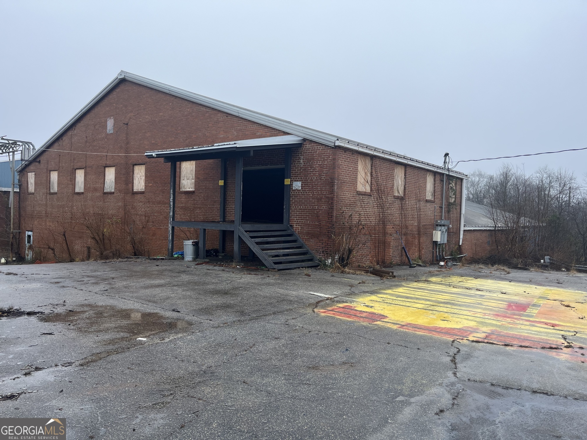 This 19,200 SF, four-sided brick building sits on a fully fenced 2-acre lot and features street water connection with an approved septic permit. Located just outside the Griffin city limits, it's zoned C-2 (commercial) and R-5 (residential) with Mill Village overlay, offering versatile potential for a range of uses. The property's it's septic tank ready and water line ready based on usage. Owners willing to split cost of installation of both and coordinate install Don't miss this rare, well-positioned site that blends accessibility with flexible zoning in a growing area.