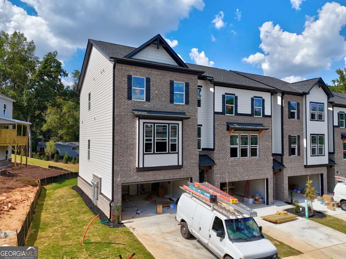 Richardson Housing Group - the Kinsley END UNIT floor plan, a 5-bedroom design with a covered and screened-in back deck in the gated community of Parkstone Row in Tucker, GA. This exclusive 33-home neighborhood is ideally located just 12 miles northeast of Atlanta and offers quick access to I-85, I-285, and Highway 78, placing shopping, dining, parks, and local events all within convenient reach. Parkstone Row is also located in the highly regarded Parkview High School District, making it a top choice for buyers seeking quality schools and convenience. The homes in Parkstone Row feature a premium list of modern finishes that outshine the competition. Brick exteriors with cedar accents, 3/4 view front doors, and 30-year architectural-style shingle roofs create curb appeal and long-lasting value. Inside, you'll find designer kitchens with quartz countertops, shaker-style cabinetry, stainless steel appliances, subway tile backsplash, and pendant lighting over the island. High-end details continue throughout with 1x6 baseboard trim, 1x4 door casings, 1x4 window surrounds, 5-panel interior doors, flat-panel wainscoting in the foyer and dining area, black hardware and fixtures, oak site-finished stained hardwood stairs, and fully tiled master showers on the floor and walls with frameless glass doors. LVP flooring extends through the main level and continues upstairs in the common areas, providing both durability and style where it's often overlooked. All 3 levels feature 9-foot ceilings, and the main level is enhanced by 6-foot-tall windows that fill the space with natural light. Each home also includes an electric vehicle charging outlet. HOA dues cover lawn maintenance, termite bond, and select exterior building maintenance, offering a low-maintenance lifestyle in a secure, gated setting. The photos shown are of the actual home currently listed for sale and will be updated as construction advances. Ask about up to $10,000 in closing cost incentives when using an approved lender, plus options for 100% financing or a 1% below-market interest rate.