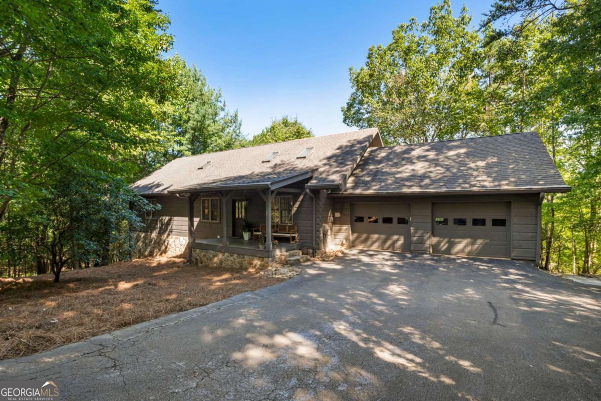This stunning mountain retreat is nestled on a quiet, wooded lot in the desirable southern section of Big Canoe with seasonal mountain views and bordering the golf course. This beautifully maintained 4-bedroom, 3-bath ranch home offers main-level living at its finest, along with a fully finished terrace level and exceptional privacy. Inside, you'll find an open and airy floor plan accented by hardwood floors, a stacked stone fireplace, and designer finishes throughout. The kitchen has beautiful granite countertops, abundant cabinetry, and modern appliances. The spacious primary suite, conveniently located on the main level, includes an updated en-suite bath and generous closet space. The terrace level expands your living options with a large recreation/media room, a kitchenette, a flex room suitable for a home office, and a second laundry area. Outdoor living is equally inviting, featuring a large, screened porch that is perfect for relaxing in the peaceful natural surroundings and taking in the seasonal mountain views. Set back from the street for ultimate privacy, this home is ideally located near community amenities and close to the back gate for easy access. **A mandatory $4,500.00 capital contribution fee paid by the purchaser to the Big Canoe Property Owners' Association will be due at closing. **Pursuant to Article II, Section 1, Paragraph bb of the Class "A" Covenants for the Big Canoe community, all property transfers are subject to the Big Canoe developer's right of first refusal.