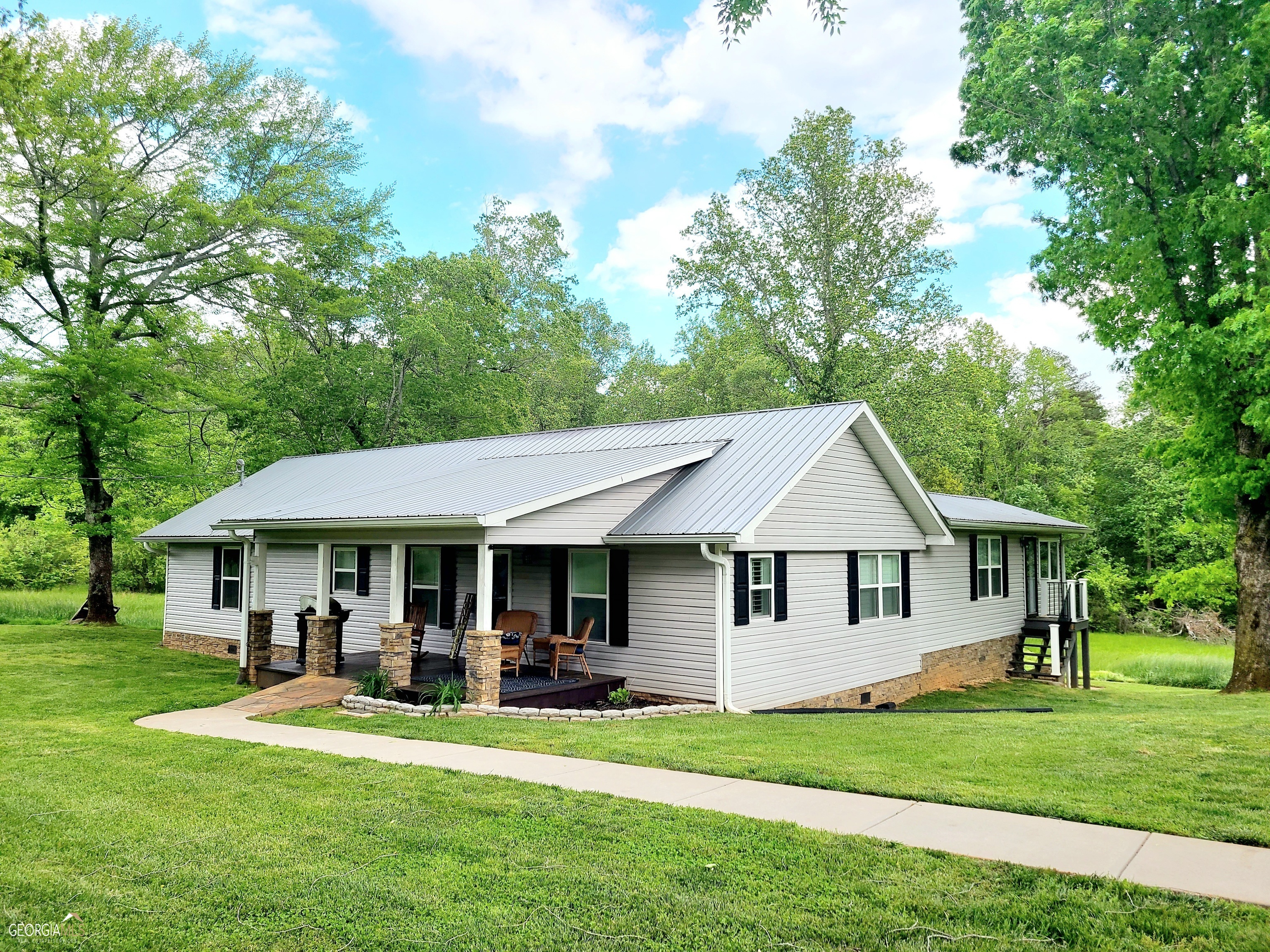 Come and see this one-of-a-kind ranch home on almost 7 acres of land! The inside features custom cabinets, granite countertops, plantation blinds, a large master suite with sunroom and stained-glass doors, a custom master closet, a large air bathtub in master bath, and separate shower. There is all new LVP flooring throughout, all newer windows, new interior and exterior doors throughout, and all new plumbing. A new HVAC unit was installed in 2016 with all new ductwork. Outside features a covered rocking chair front porch, a new large back deck completely redone with Trex deck in 2022, new stonework on the base of the home and entryway pillars. Absolutely incredible metal garage with 2 large bay doors that is run with electricity and water. There are 2 rooms inside the garage that can be used as an office, spa, or man cave. The large back yard is a perfect spot to enjoy the many opportunities for activities, hobbies, or entertaining or even a pool. There is also a shed to store a trailer, tractor, or any kind of equipment. In the back of the home, a storm shelter was built in case of severe weather. Come and see what all opportunities this incredible home has to offer!