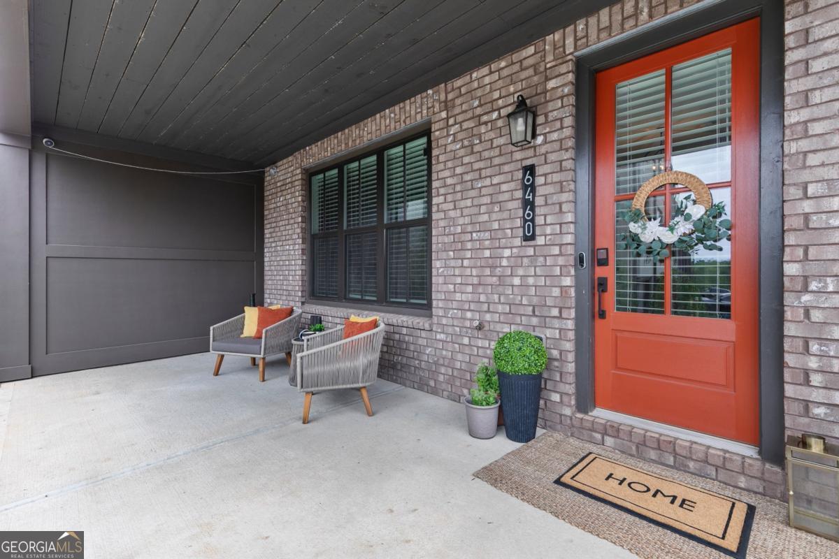 Modern 3-Story Corner Townhome in the Heart of Halcyon - Alpharetta, GA Welcome home to this stunning 4-bedroom, 3.5-bathroom corner townhome in the highly desirable Halcyon community - where style, comfort, and location come together beautifully. Built in 2021 and move-in ready, this home features hardwood floors on all levels (no carpet!), a 2-car garage, and elevated finishes across three spacious levels. Step onto the inviting covered front porch - the perfect spot to enjoy your morning coffee or unwind in the afternoon - and enter into a bright, open foyer on the lower level. This floor includes a guest bedroom with views of the porch, a full bathroom, a large storage closet, and a convenient built-in bench near the door to the garage. There's also a second entrance at the back of the home next to the garage for added convenience. The main level is designed for everyday comfort and entertaining. The gourmet kitchen boasts quartz countertops, a large island with sink and seating, a gas cooktop with vent hood, built-in oven and microwave, 3-door stainless steel fridge, tile backsplash, and a large walk-in pantry. Across the kitchen, a bar nook with wine cooler and stone counters offers a stylish touch. The dining area is located near a tucked-away desk nook, ideal for a home office setup. The cozy living room, complete with a gas fireplace, opens up to a private deck, perfect for indoor-outdoor living. Upstairs, you'll find the owner's suite featuring tray ceilings, a spa-inspired bathroom with double vanities, a glass-enclosed walk-in shower, a private water closet, and a generous walk-in closet with built-ins and natural light. Two additional guest bedrooms share a full bathroom with a stone countertops vanity and shower/tub combo. A laundry room with washer and dryer and a large linen closet provide extra convenience. As an added bonus, this home has elevator potential - three oversized closets located on each level (including the pantry on the main floor) are perfectly aligned to be converted into an elevator shaft in the future, if desired. The Halcyon community offers the ultimate live-work-play lifestyle, with walkable access to top-tier shopping, dining, and entertainment - including Trader Joe's just down the street! Community amenities include a covered gazebo for events, green space, a sparkling pool, and a cozy firepit area perfect for socializing year-round. Unbeatable Location: Just off GA-400, you'll enjoy easy highway access for a quick commute to Atlanta, top-rated schools, and everything North Fulton has to offer.Location. Comfort. Community. This townhome checks all the boxes - schedule your tour today and make it yours!