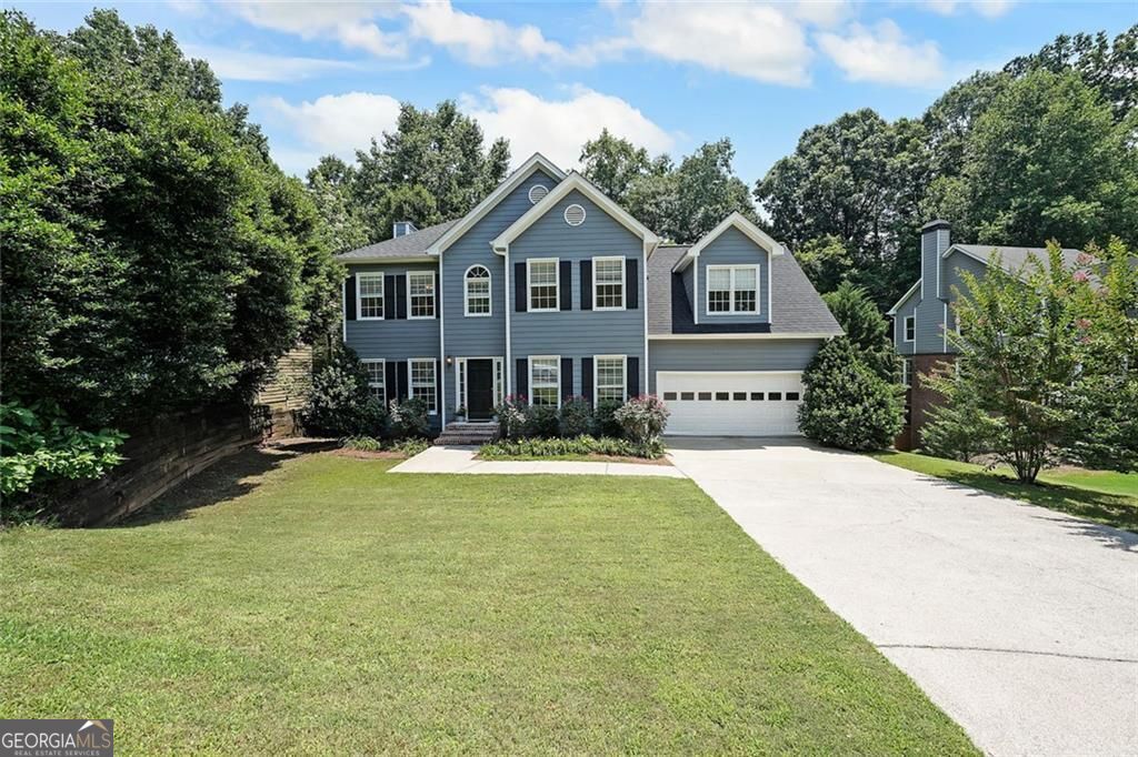 Welcome to your dream home! This beautiful 4-bedroom, 2.5-bath residence is nestled in one of the area's most desirable swim and tennis communities. The open-concept layout is perfect for entertaining, featuring hardwood floors throughout the main level, a formal dining room, and a spacious great room with a cozy fireplace. The kitchen opens to a sunny eat-in area and includes a breakfast bar-ideal for casual dining and gathering. There's also plenty of room for a home office on the main level, offering flexibility for work or study. Upstairs, the oversized primary suite is a true retreat, complete with a spacious ensuite bathroom. You'll also find an exceptionally large secondary bedroom, along with a hall bathroom and two other generously sized bedrooms-offering space and versatility for any lifestyle. Step outside and enjoy the expansive two-tiered deck overlooking a private, wooded backyard-perfect for relaxing, entertaining, or dining al fresco. Conveniently located between Roswell and downtown Woodstock, you'll enjoy easy access to top-rated schools, shopping, dining, and entertainment-all just minutes away.