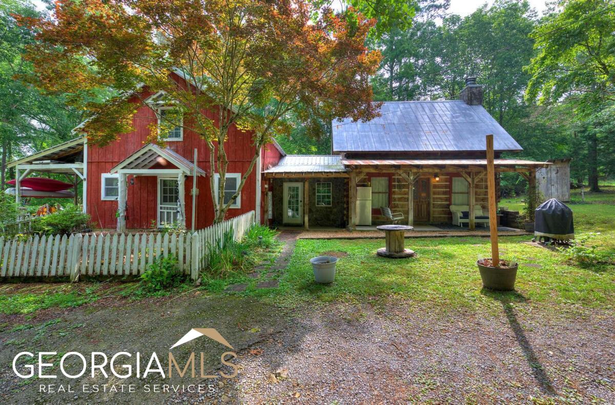 Don't miss this opportunity to own and operate your own working farm! Located near Downtown Kingston, this peaceful log cabin homestead is surrounded by timberland and backs up to Barnsley Gardens. This property features mature fruit trees: plums, pears, mulberries, kiwi and cherries. The garden that sits outside the kitchen provides delicious blueberries and blackberries. Five +- acres provide a ton of space for the chickens, goats, ducks and guardian dogs. The space for the animals is enclosed with fencing and is complete with a goat stall, and chicken coop. The farmhouse log home sits close to the center of the property, has a has 3 BR / 2.5 BA, offers an entry through the tranquil rocking chair front porch. Maintenance free cement flooring is a prime feature of the main floor. The owner's suite is also on the main, and there are two bedrooms upstairs with a half bath. The batten board kitchen comes complete with a wood burning stove to assist with heating and provides a great eat in space for family dinners and visiting with friends. The spacious great room has a large stacked stone fireplace with a generously sized loft. Laundry sits on main in conjunction with second bathroom. A pole barn, specifically for wood storage sits at the back of the house. All lights on main floor and thermostat are blue tooth. This home offers all the comforts of city living, combined with being just outside "the city". Call for your appointment today!