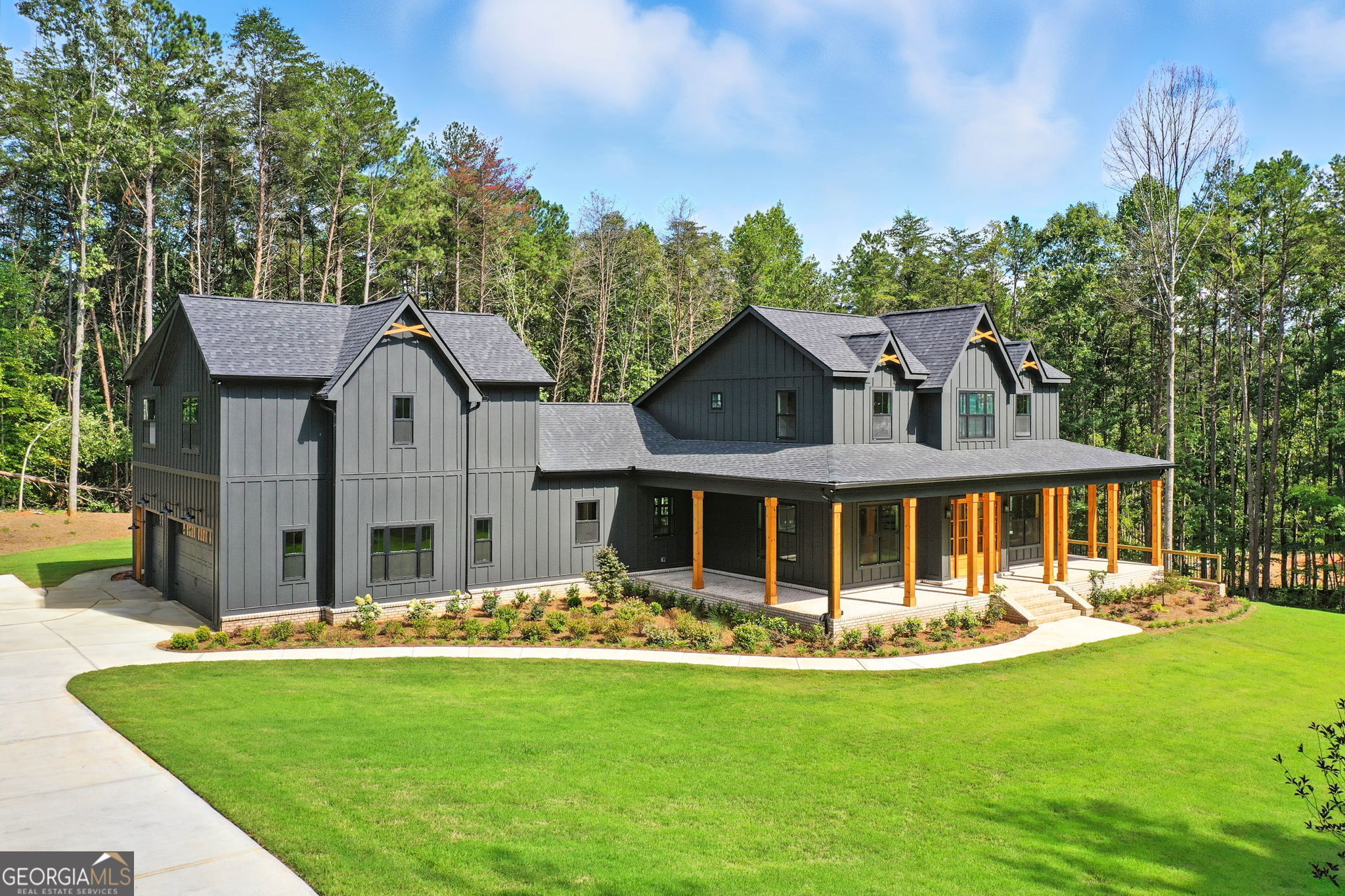 Exceptional New Construction Estate in The Highlands at Sharp Mountain with Seller offering to give $125,000 allowance toward inground pool! Experience elevated living in this newly constructed almost 8.000 sq ft estate, where bespoke design meets refined elegance in one of North Georgia's most exclusive gated communities. Set on 5 pristine acres within The Highlands at Sharp Mountain, this architectural showpiece commands attention with its striking black exterior, timeless brick accents, expansive covered front porch, rear veranda, and oversized three-car garage-a bold statement of modern sophistication. Step inside to a light-filled, open-concept interior where wide-plank real white oak hardwoods lead you through a seamless flow of curated living spaces. The expansive family room anchors the heart of the home, while the chef's kitchen impresses with Wolf and Sub-Zero appliances, custom cabinetry, a dramatic quartz island, and a fully equipped secondary prep kitchen, a bar hall with a wine and beverage cooler-designed for effortless entertaining. The main-level owner's suite is a private sanctuary, featuring a spa-inspired bathroom and generous walk-in closets with seller offering a $10k allowance toward closets customization. An additional main-level guest suite with a full bath, along with a stylish powder room, offers comfort and convenience for visitors. A spacious laundry room connects to a secondary staircase that leads to a private guest suite above the garage, complete with its own full bath-ideal for multi-generational living or a private office. Upstairs, two thoughtfully designed bedrooms each offer en-suite baths, providing a perfect blend of comfort and privacy. The full, unfinished terrace level-over 3,000 sq ft-invites endless possibilities, from a custom home theater or fitness center to a workshop or expanded storage. Some addional features are a Daikin Smart Sytem for HVAC, as well as a Rinnai Tankless Water Heater! Seller is also offering to give $125,000 allowance toward inground pool! Located within an intimate enclave of just 21 estate-sized homesites, this home offers a rare combination of seclusion and accessibility-just minutes from historic downtown Ball Ground, top-rated schools, I-575, Canton Marketplace, Northside Hospital, and the scenic beauty of the North Georgia mountains. Luxury, privacy, and convenience-reimagined. Welcome home.