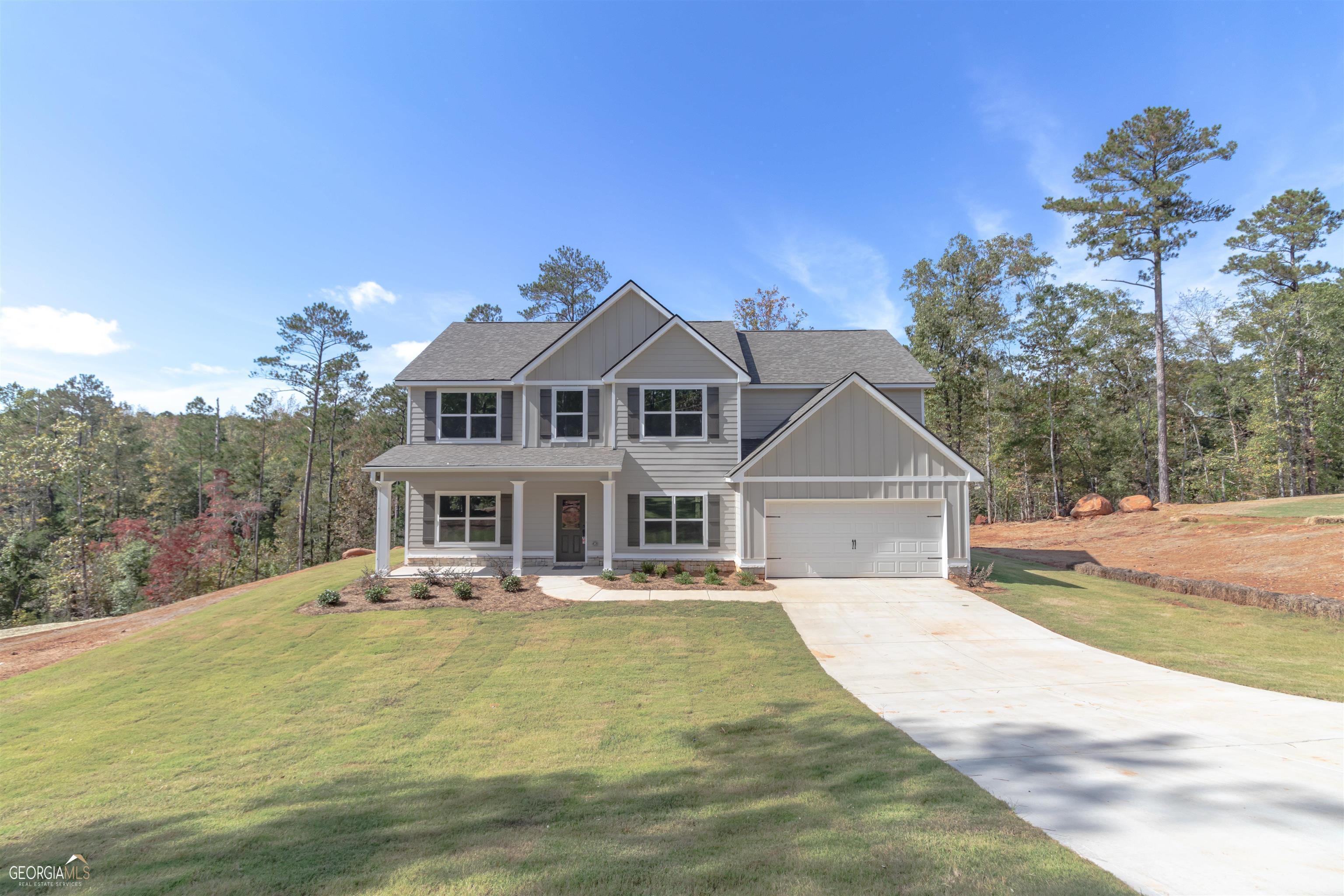 GREAT TWO STORY TIMBERLAND PLAN IN UPSON COUNTY - NESTLED ON 2.2 ACRES AND NO HOA! This beautiful 4 bedroom, 3 bath home has foyer entrance, large family room with exposed beam vaulted ceiling and brick surround wood burning fireplace, open concept Kitchen and breakfast area with luxurious designer finishes such as granite or quartz countertops, tiled backsplash, stainless steel appliance package. Second living or flex space on the main level plus one guest room and full bathroom downstairs. Large owner's suite upstairs w/ensuite bath including double vanities with granite or quartz, separate soaking tub and tiled shower plus huge closet. Two additional bedrooms are upstairs, each with walk in closets, and share a full hall bath. Laundry and oversized bonus room are both upstairs too. Covered front and back porches with mud room entry from the attached double garage.