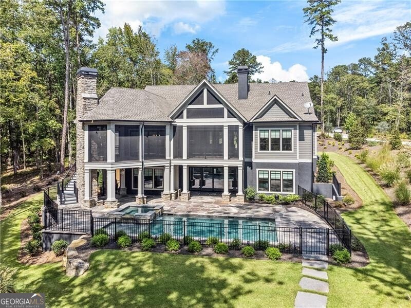 Indulge in the epitome of lakeside luxury with this exquisite 6-bedroom, 7-bathroom retreat nestled within Richland Pointe in Reynolds Lake Oconee. Boasting panoramic lake views and soaring high ceilings, this residence seamlessly combines opulence with tranquility. Unwind on the screened porch, surrounded by nature's beauty, and relish in the perfect fusion of elegance and comfort that defines this exceptional home. Enjoy the enchanting ambiance of two outdoor fireplaces, complemented by a pristine pool and inviting hot tub, creating a complete oasis of relaxation. Inside, a grand fireplace sets the tone for cozy evenings. Elevate your culinary experience in the chef's kitchen, designed with beauty and functionality in mind. Beyond the culinary haven, discover the blissful sanctuary in the stunning master-on-main bedroom, offering a harmonious blend of comfort and sophistication. Within the en-suite, you'll find a soaking tub with separate shower, two vanities, and a walk-in-closet fit for even the most extensive of wardrobes. With a second bedroom on the main floor, guests can experience comfort and convenience. Beyond the mudroom and up to the third floor, you are greeted by two more bedrooms and full baths, perfect for accommodating guests or creating the home office of your dreams. On the lower level, a kitchenette and additional entertainment space await. In addition to the two lower floor bedrooms with en-suites, there is plenty of space to build your own gym, movie theater, or something else your heart desires! Views of the saltwater pool, spa and waterfront can be viewed from the sliding glass doors, inviting you to jump in. Breathe in the 180 ft of private waterfront, tucked away on a cove with little to no traffic. Step outside on your private dock slip, offering ample space for your boat and jet ski, ensuring endless adventures on the water. Seller has made several upgrades, including a rock retention wall along the cove, security system, and SONOS sound system throughout the house and outside. This gorgeous home, situated on a quiet cul-de-sac, is close to golf, restaurants, spa amenities, and much more. Don't miss your opportunity to live lakeside with this one-of-a-kind retreat!