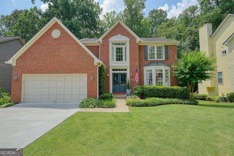 Experience the best of multigenerational living with this remarkable home. It features an in-law suite with a beautiful private entrance and private outdoor space. Nestled on a quiet cul-de-sac road, the property is within walking distance of the amenities, including a pool, lake, playground, and basketball and tennis/ pickleball courts. The highlight of this home is the expansive screened porch, complete with a fireplace, perfect for relaxation. It overlooks the private backyard oasis. The custom kitchen has been beautifully renovated. Hardwood floors flow throughout the main level. You'll also find custom-built-ins in the front room, ideal for a home office or library. The recently renovated terrace-level apartment features a full bath, great room, kitchenette, and bedroom, providing ample additional living space. Don't miss the new driveway and custom front doors, adding to the home's curb appeal. There is easy access to both I-75 and I-575 and the Express Lane. This impeccably maintained home provides plenty of room for the entire family to spread out and enjoy.