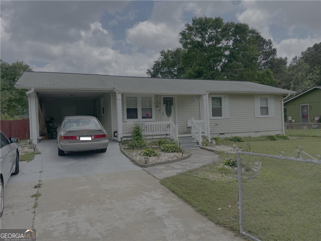 Three bedroom ranch home with hardwood floors, vinyl siding, and carport. Cute front porch. Rear porch for extra outside seating, fenced backyard and a shed for storage.