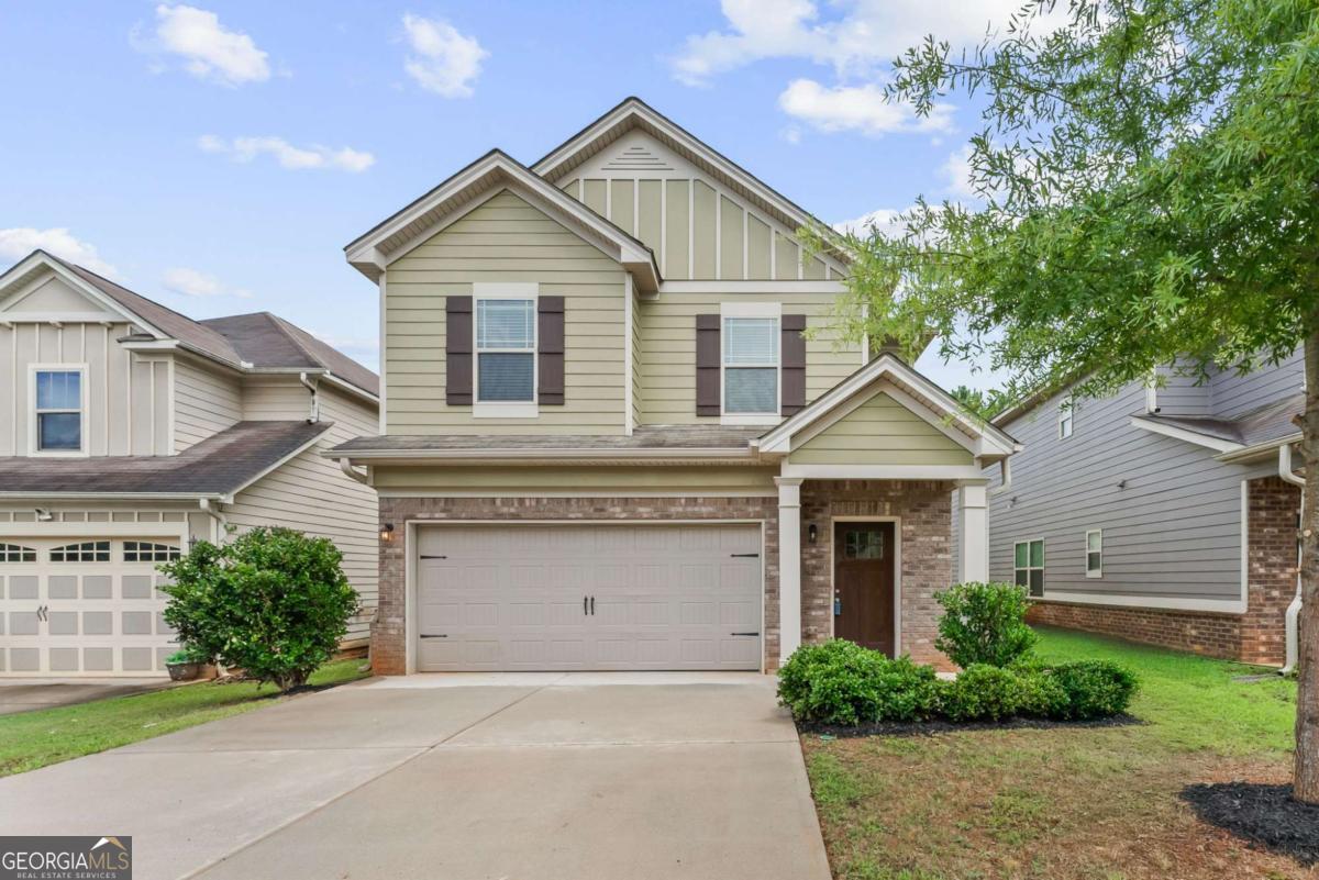 Welcome home to this beautifully refreshed 4 bedroom, 2.5 bathroom residence in the Collinswood at Locust Grove Station community! Built in 2018 and recently updated with fresh paint and brand new flooring-including LVP throughout the main level and plush carpet upstairs-this home blends modern comfort with timeless charm. Step inside to find a bright, separate dining room that flows into the stylish kitchen featuring stone countertops, stainless steel appliances, a breakfast bar, and views of the cozy fireside family room-perfect for entertaining or everyday living. Upstairs, the spacious primary suite offers tray ceilings, a large walk-in closet, and an ensuite bathroom with double vanities and a shower/tub combo. Three additional generously sized bedrooms share a full hall bathroom, and the laundry closet is conveniently located on the upper level. Enjoy outdoor living on the rear patio and the convenience of an attached 2-car garage. Ideally situated with easy access to I-75, Tanger Outlets, and a variety of shopping and dining options-this home is move-in ready and waiting for you!