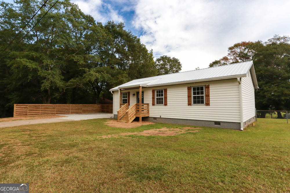 Charming and fully renovated, this 3-bedroom, 1-bathroom home in Carrollton is move-in ready and just steps from everything downtown has to offer. Located only 0.8 miles from Adamson Square, you will be close to shopping, dining, and entertainment. Inside, the home has been beautifully updated with brand new LVP flooring, a modern kitchen featuring stainless steel appliances, new countertops, and fresh cabinetry. The stylish tile bathroom adds a touch of luxury, while the new metal roof provides long-term peace of mind. The fenced-in backyard is perfect for outdoor living and pets, and a storage building offers space for tools, lawn equipment, or hobbies. A spacious wraparound back deck with a swing provides the ideal spot to relax, entertain, or simply enjoy the outdoors, all with the added bonus of backing up to a Carrollton city park for extra green space and privacy. With its prime location and top-to-bottom updates, this home is the perfect blend of comfort, convenience, and modern living.